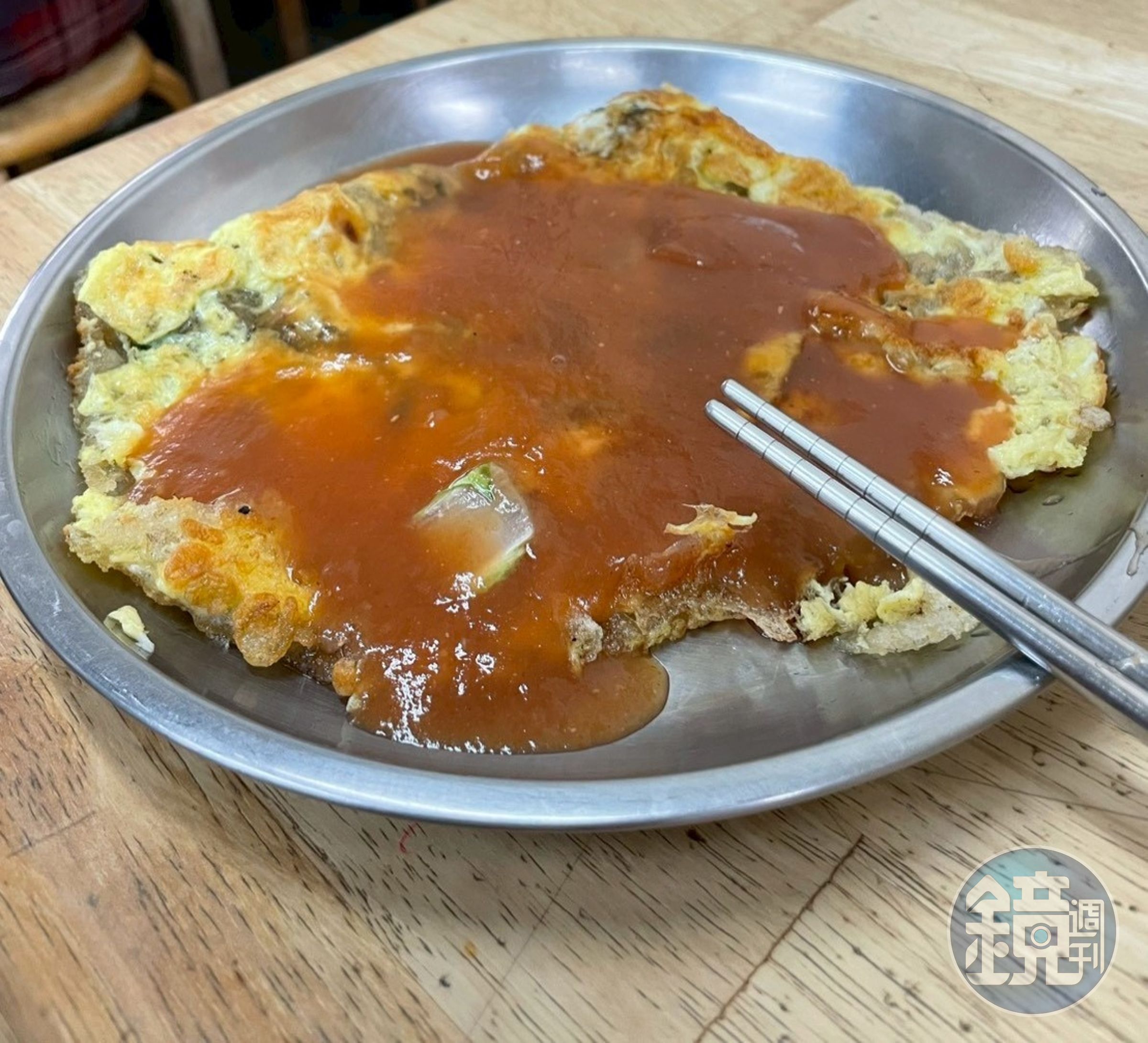 布袋鮮之蚵的蚵仔煎不同於一般常見的圓形，老闆會反覆折疊成方形的包袱，再淋上淡紅色的鹹甜醬汁。(鏡好聽提供／吳芳碩攝)