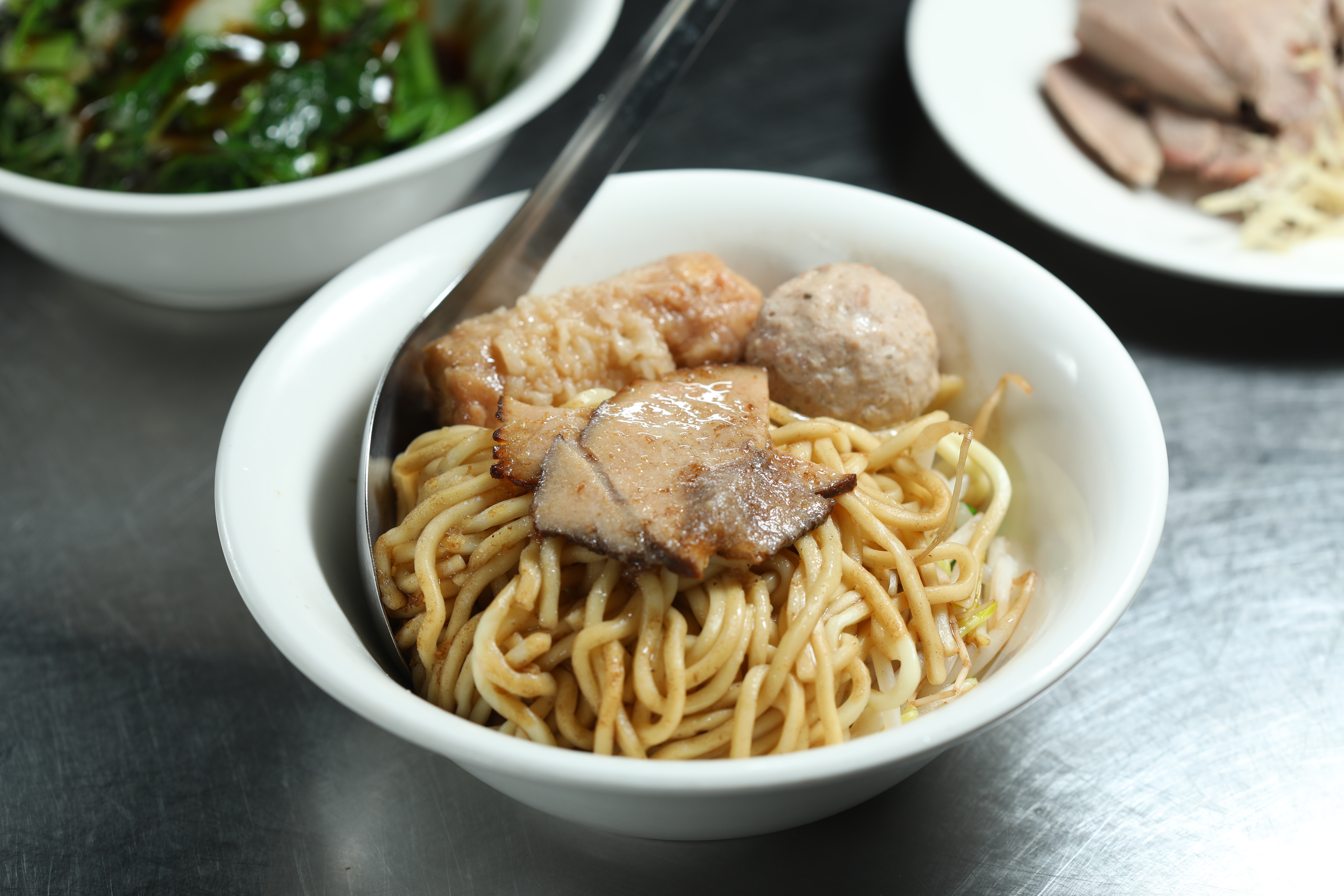 「麵哥麵嫂」的「乾麵」會附自製的雞捲、丸子和肉片，口味做得很細緻。