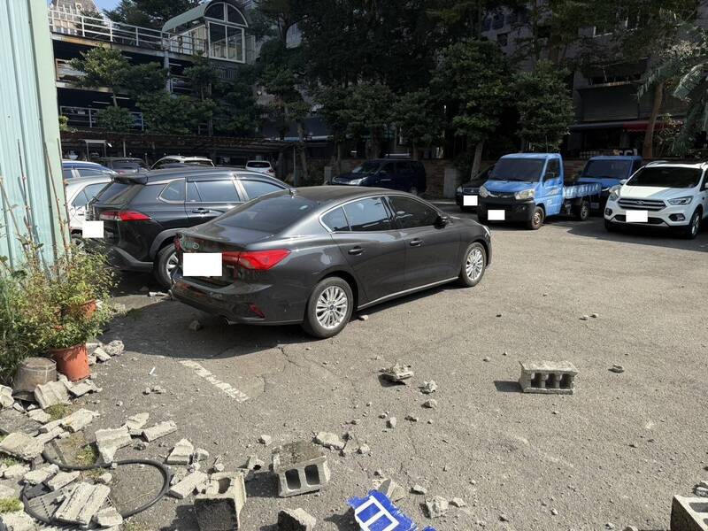 國民黨台中黨部停車場23日發生車禍,圍牆遭撞,石塊四散一地。(翻攝畫面)
