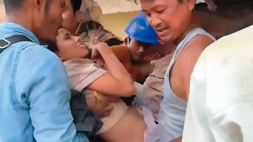 地震後，緬甸民眾合力從瓦礫堆中救出生還者。（緬甸台商提供）