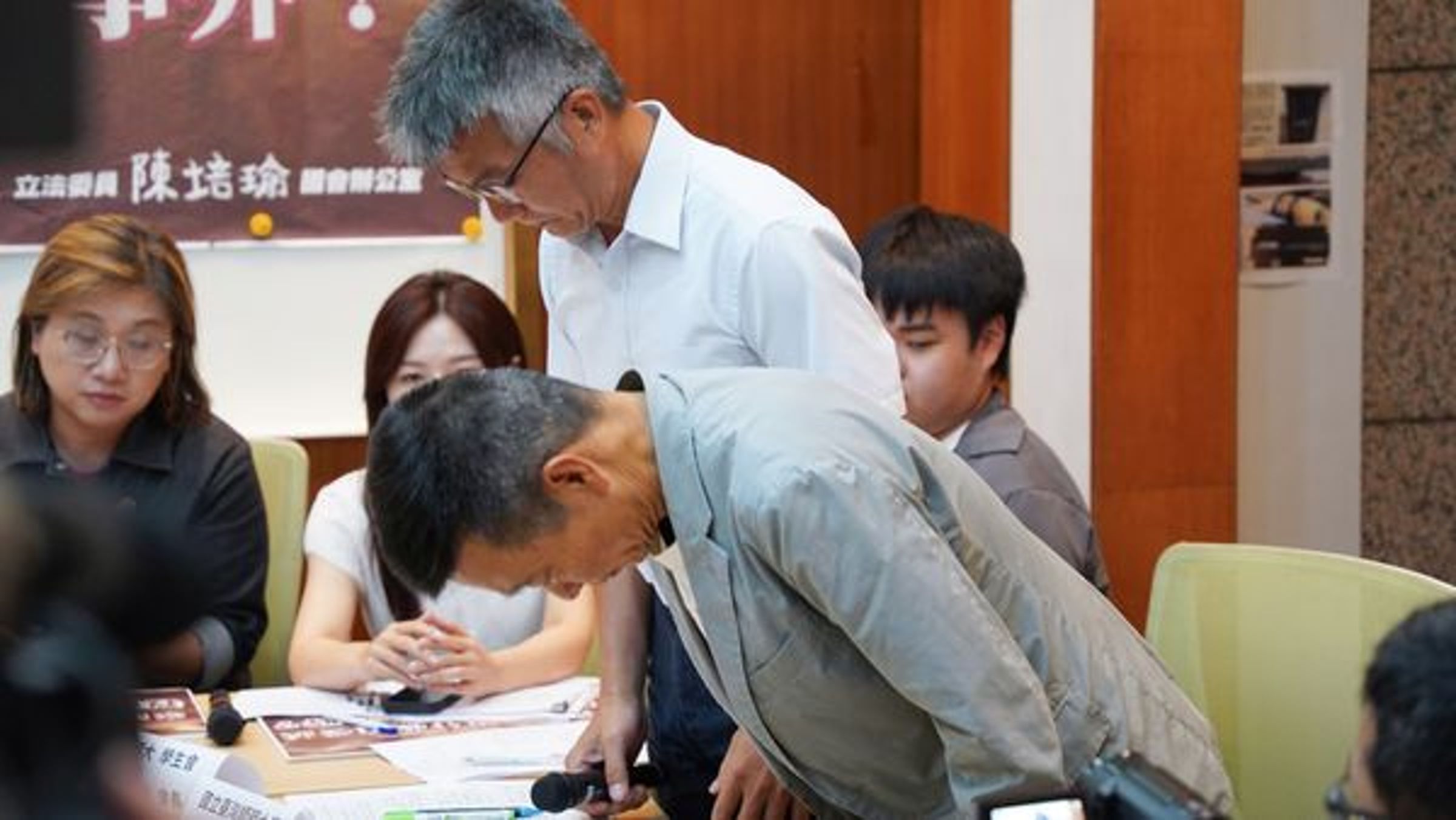 台師大學運動與休閒學院院長王鶴森(白衣)代表學校公開致歉,體育室主任李佳融(灰衣)也鞠躬道歉。(范雲國會辦公室提供)