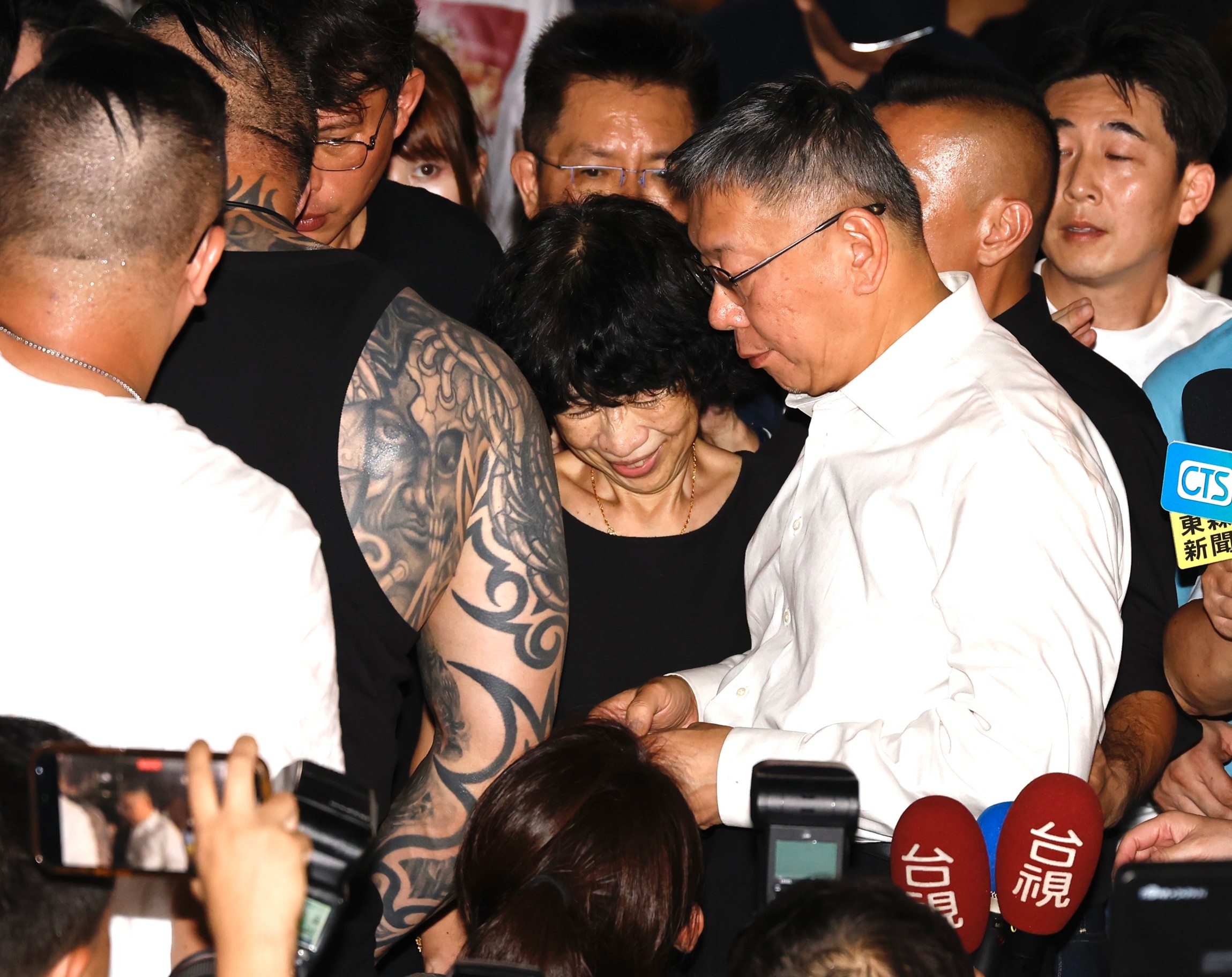 法院今日凌晨裁定民眾黨主席柯文哲（白色襯衫者）無保請回，柯步出法院被支持者包圍。