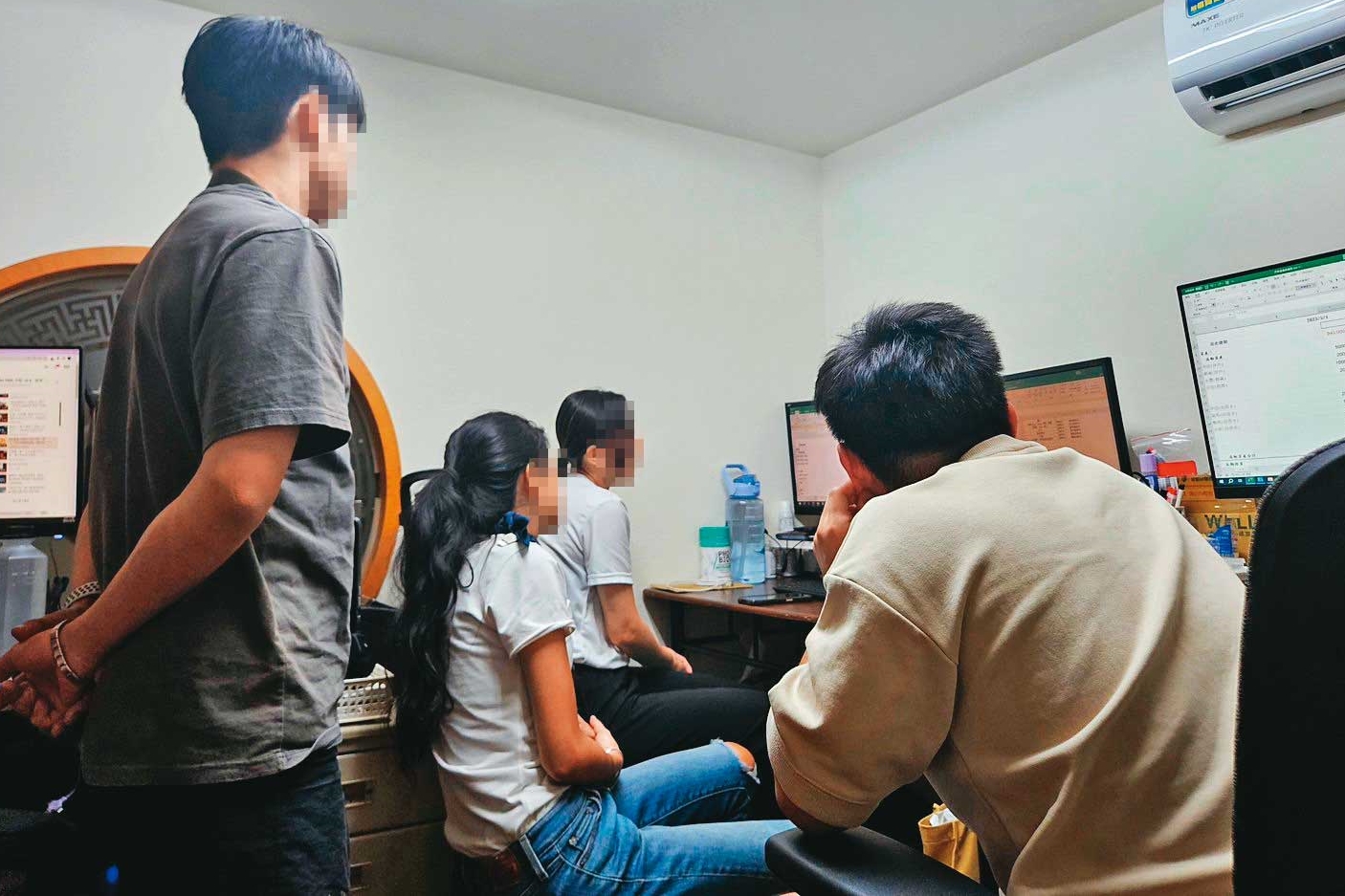 資產公司員工們及李孟儒圍著電腦螢幕，討論如何幫債務人辦信貸、信用卡。（讀者提供）