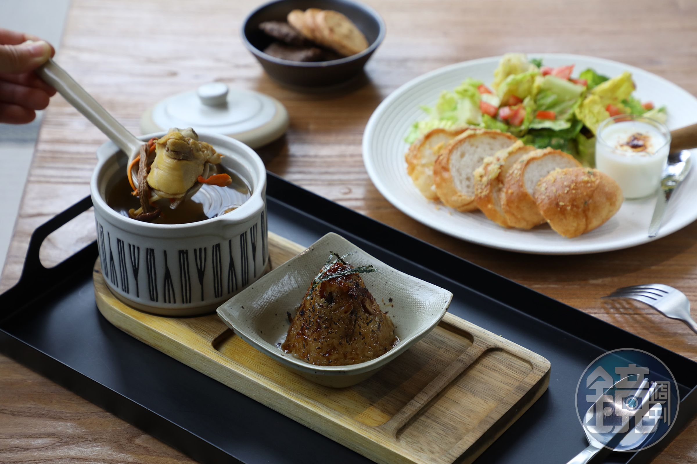 「慢熬四小時的菇菇雞湯」（左，180元／份）與「火烤炙燒古法油飯糰」（右，90元／個）是與主打功夫煲湯「奉湯」合作的餐點；「北海道蒜味乳酪軟法沙拉」選用「一日一步」的麵包。（250元／份）
