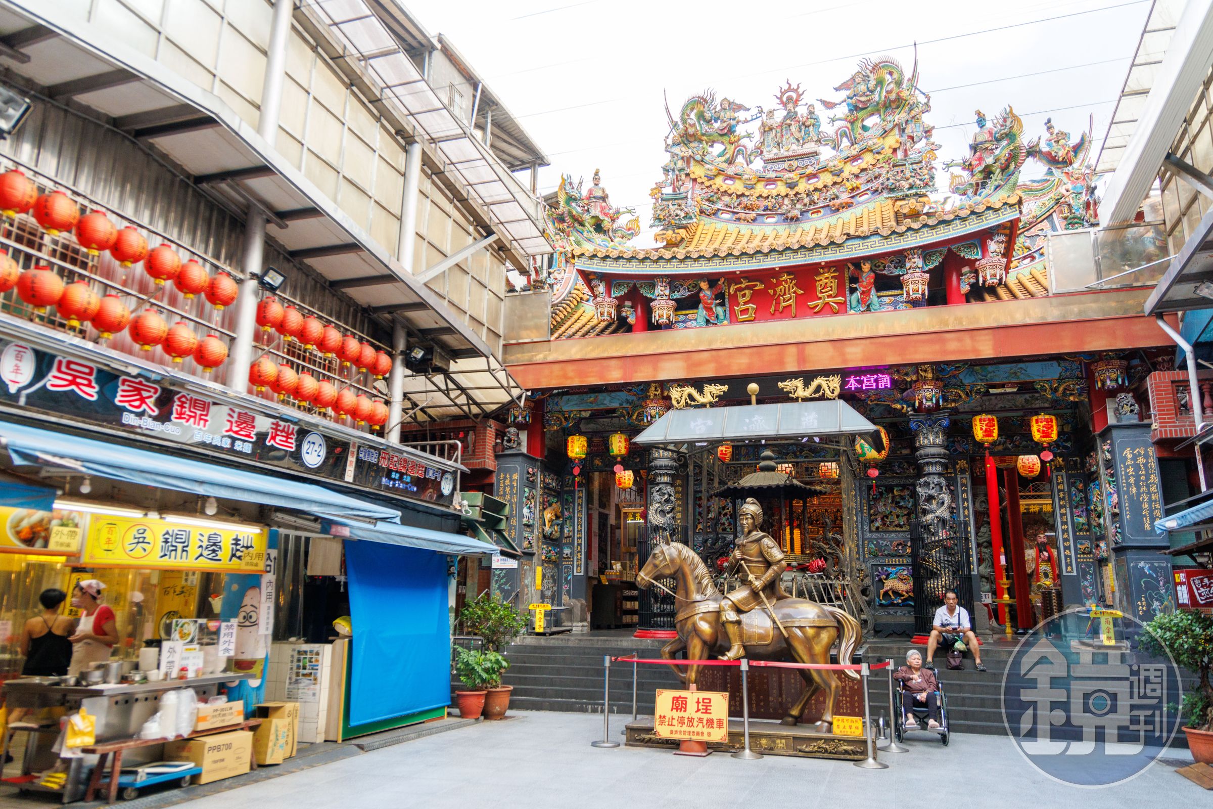 數不清的小吃店從奠濟宮兩旁延伸出去，門口塑像即是開漳聖王陳元光將軍騎馬英姿。