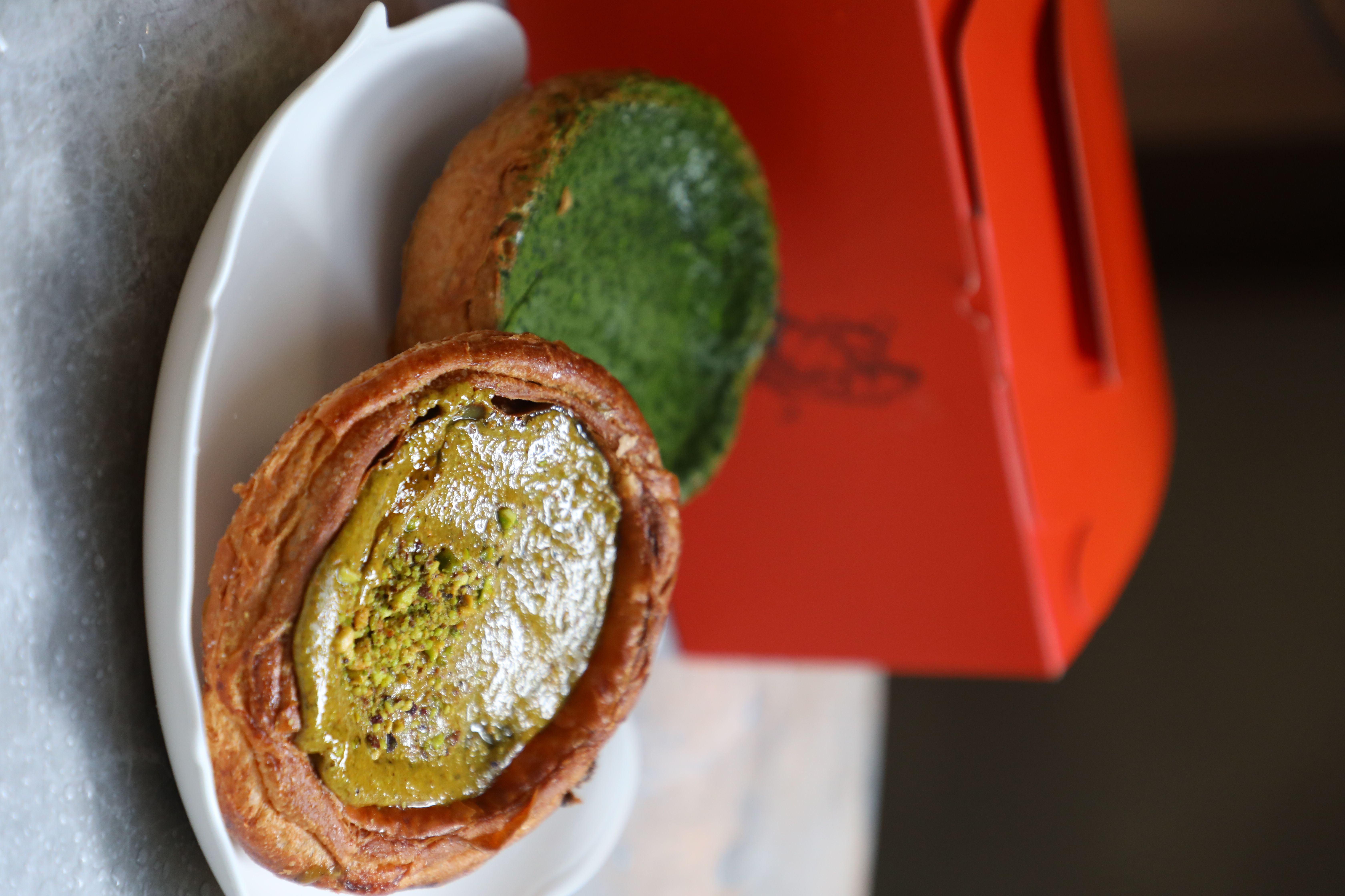 會流漿的濃郁開心果丹麥酥「Pistachio custard danish」（前，港幣68元／個）與苦甜口味有麻糬夾心的「Matcha Mochi custard danish」（後，港幣60元／個）都是熱賣商品。