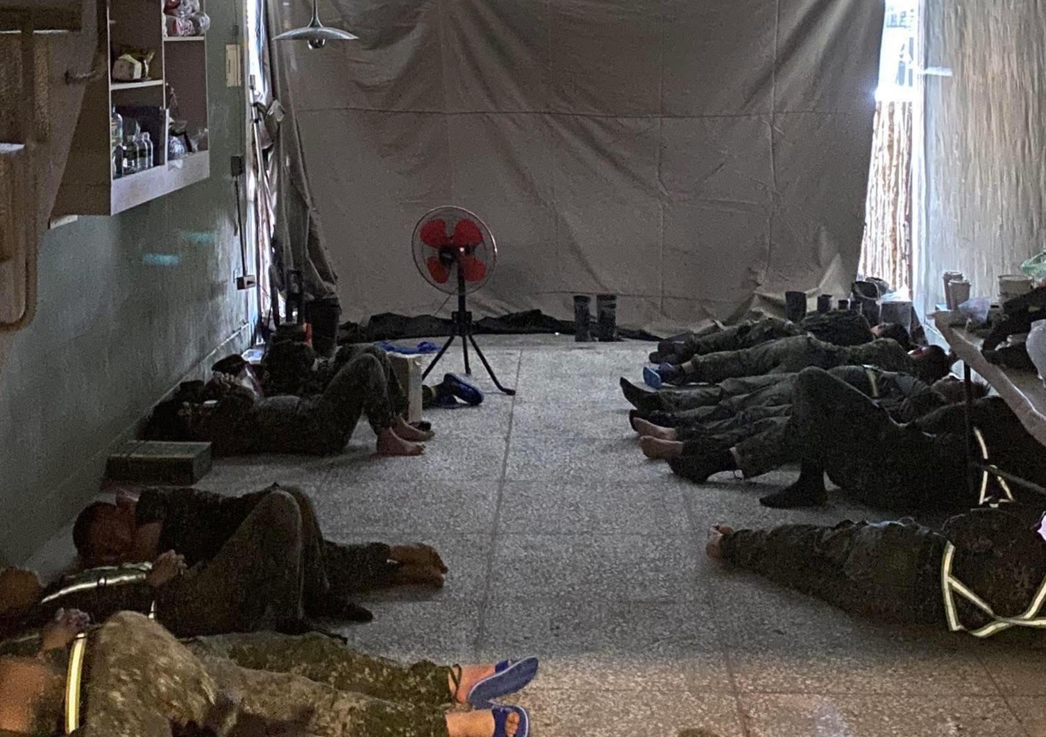 光復鄉災區，國軍弟兄清淤作業後累癱地上休息，屋主貼心拉上布簾遮陽、阻擋泥沙，讓大家能安心休息。（翻攝自爆料公社）