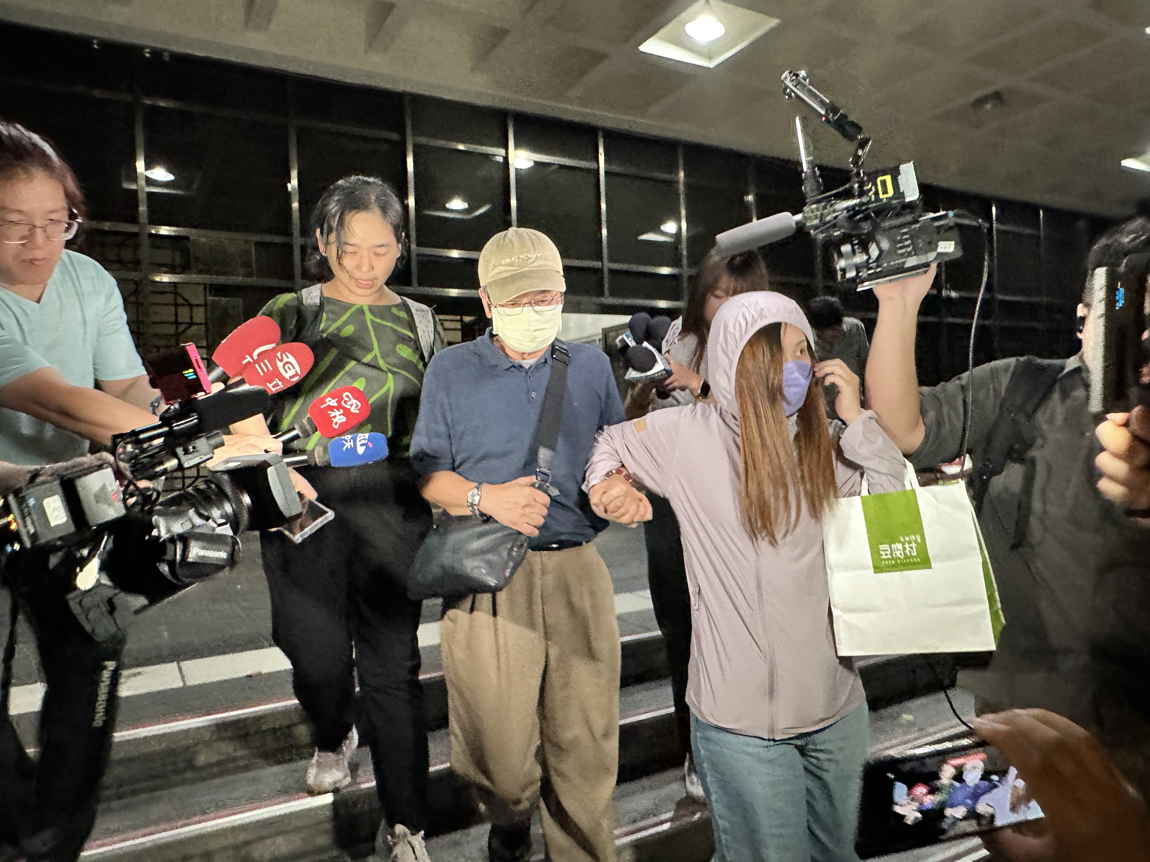 李文宗(中)被轉為被告約談，訊後200萬元交保。左為律師唐于智。