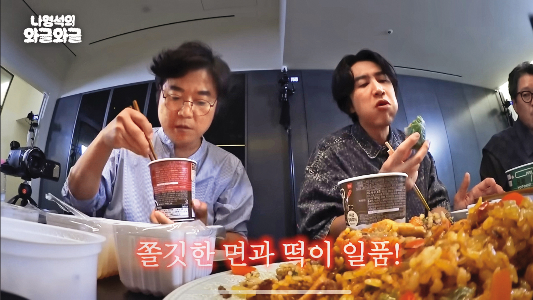 韓國速食辣炒年糕置入製作人羅暎錫（左）的節目《羅暎錫的吵吵鬧鬧》，他與來賓李光洙（右）吃得津津有味。（翻攝自YouTube）