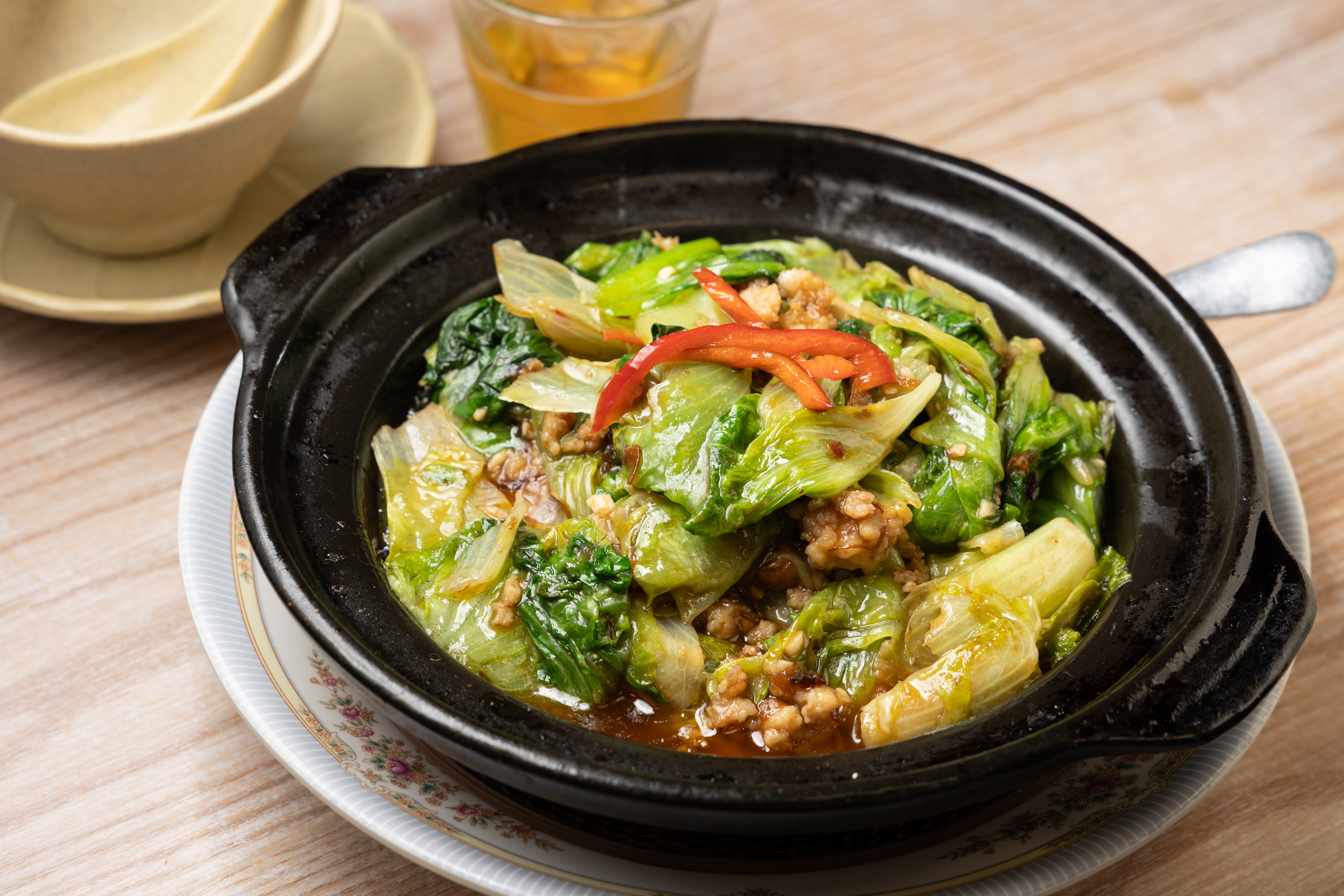 「啫啫生菜煲」的唐生菜在高溫煲中快速炒製，吸飽鑊氣，吃來帶點煙燻香氣。（港幣98元／份，約NT$370）