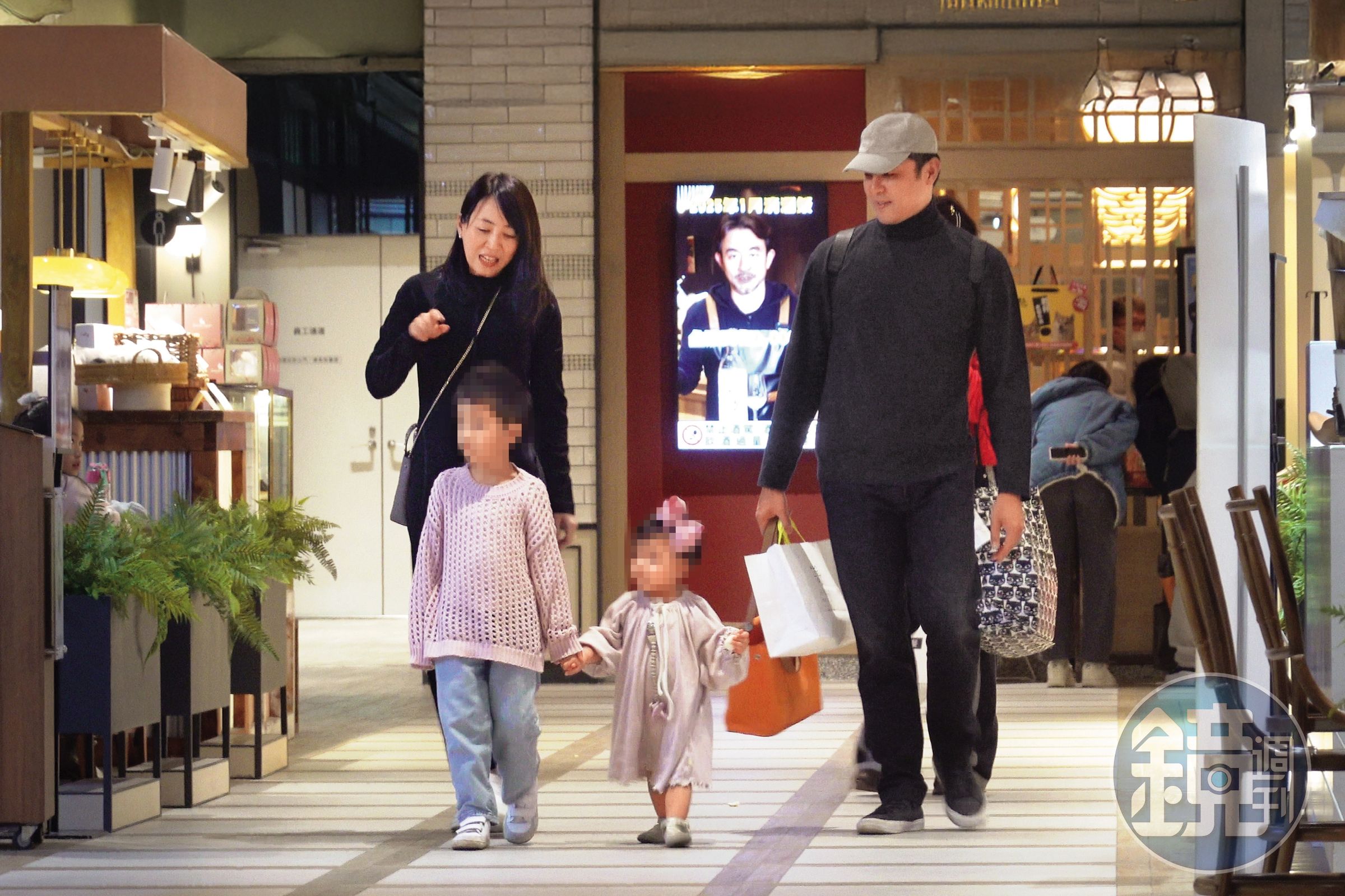 一對子女開心逛街，明道（右）在後頭十分認分當挑夫。