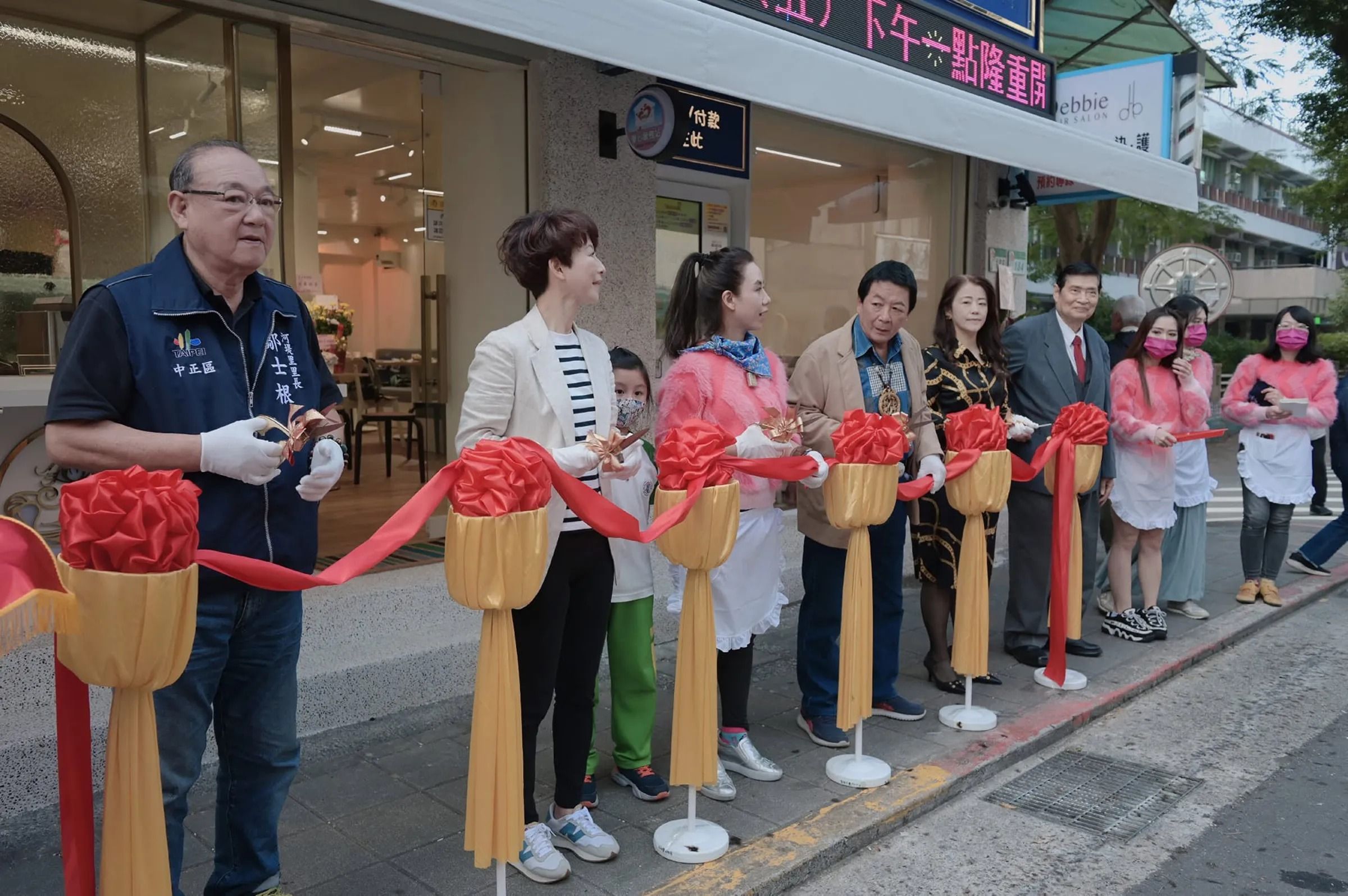童芯（左三）餐廳開幕時，曾找陳亭妃（左二）剪綵，被網友爆料其父陳宏明（左四）是賴清德、陳亭妃輔選大將。（翻攝童芯臉書）