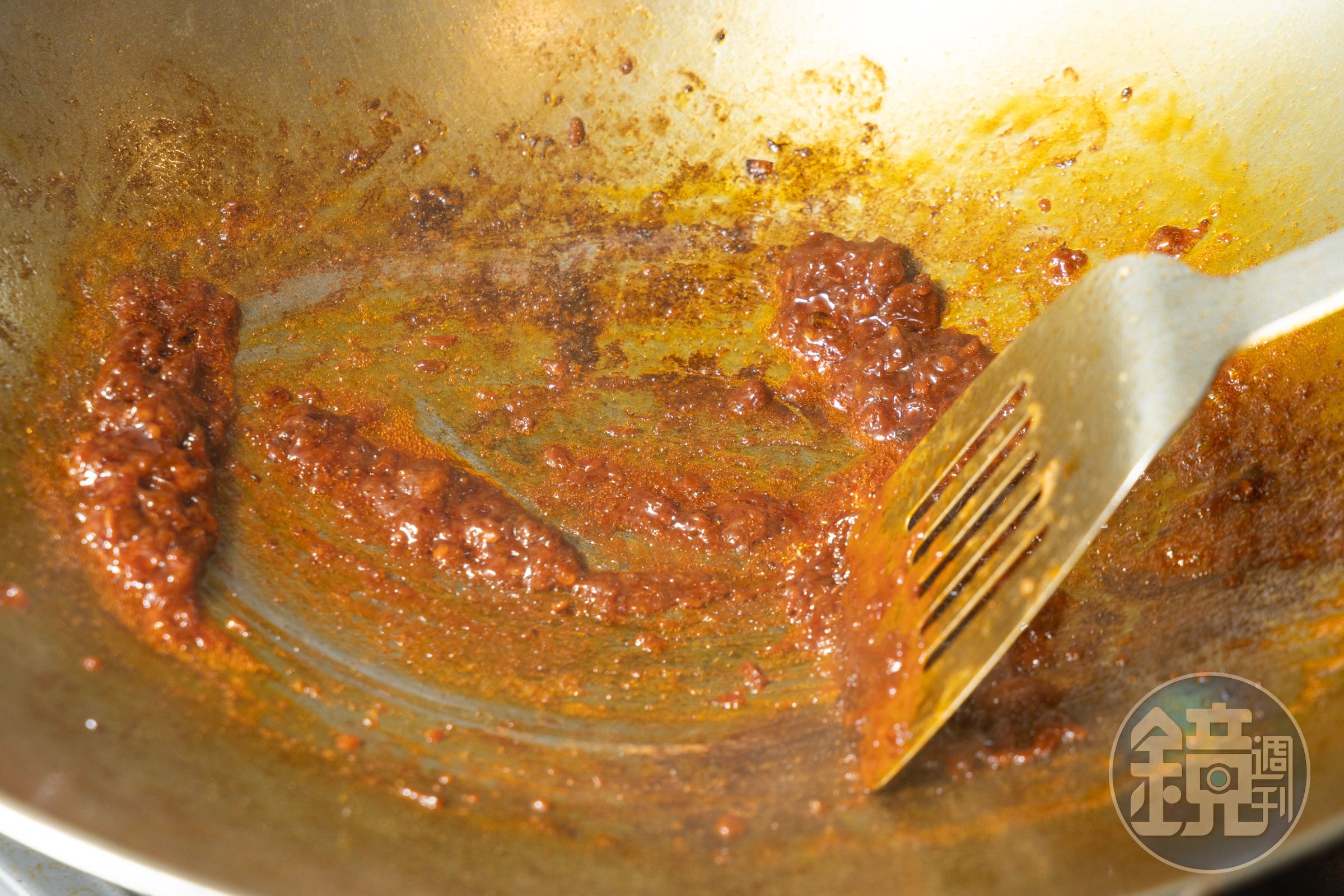 用鍋內原油爆炒一大瓢辣豆瓣醬。