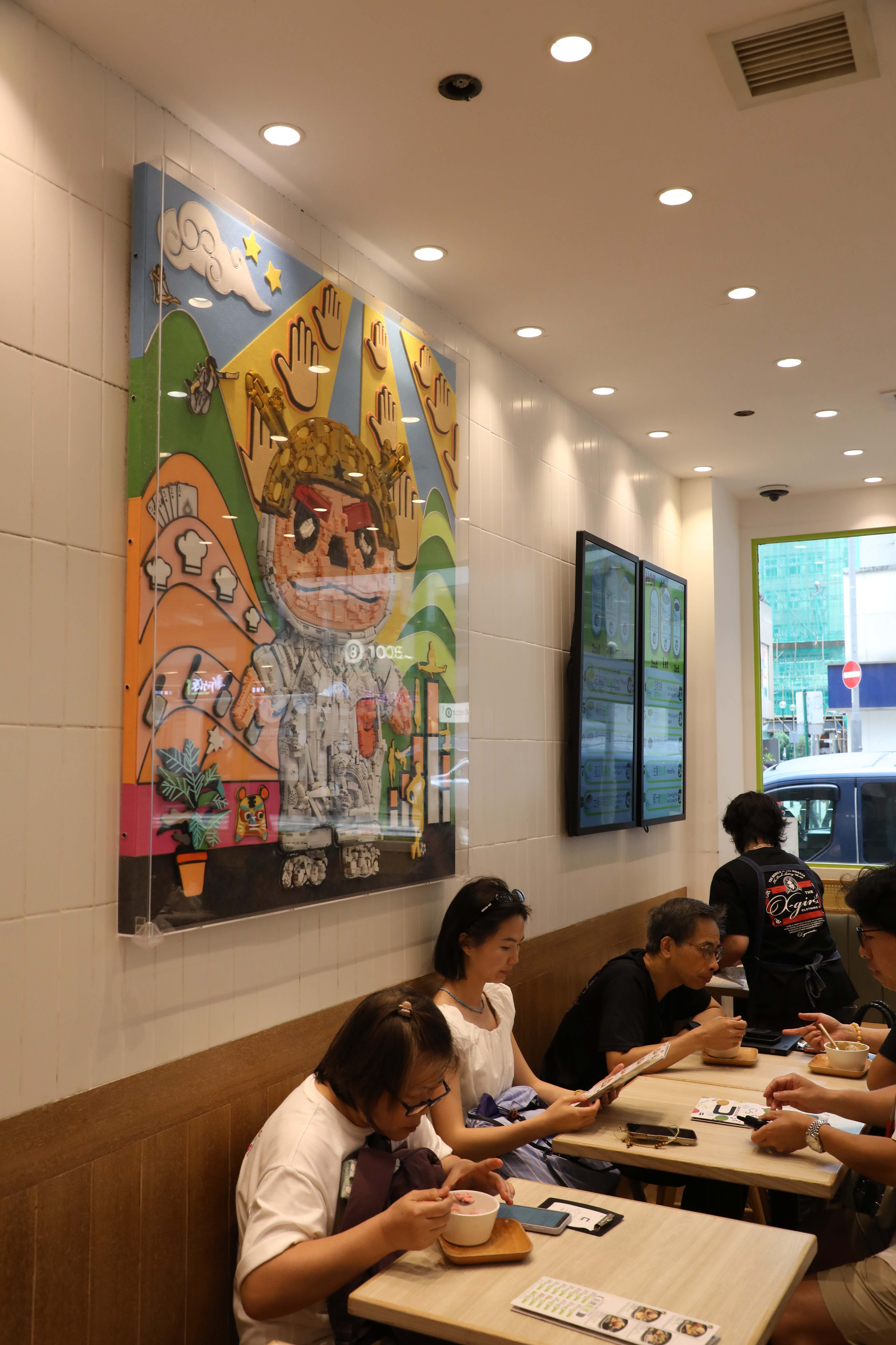 牆上的樂高創意畫以二代店主原創的龍眼吉祥物「龍吉」為主角，融入周星馳電影元素，其中也藏著不少影迷熟悉的經典彩蛋。