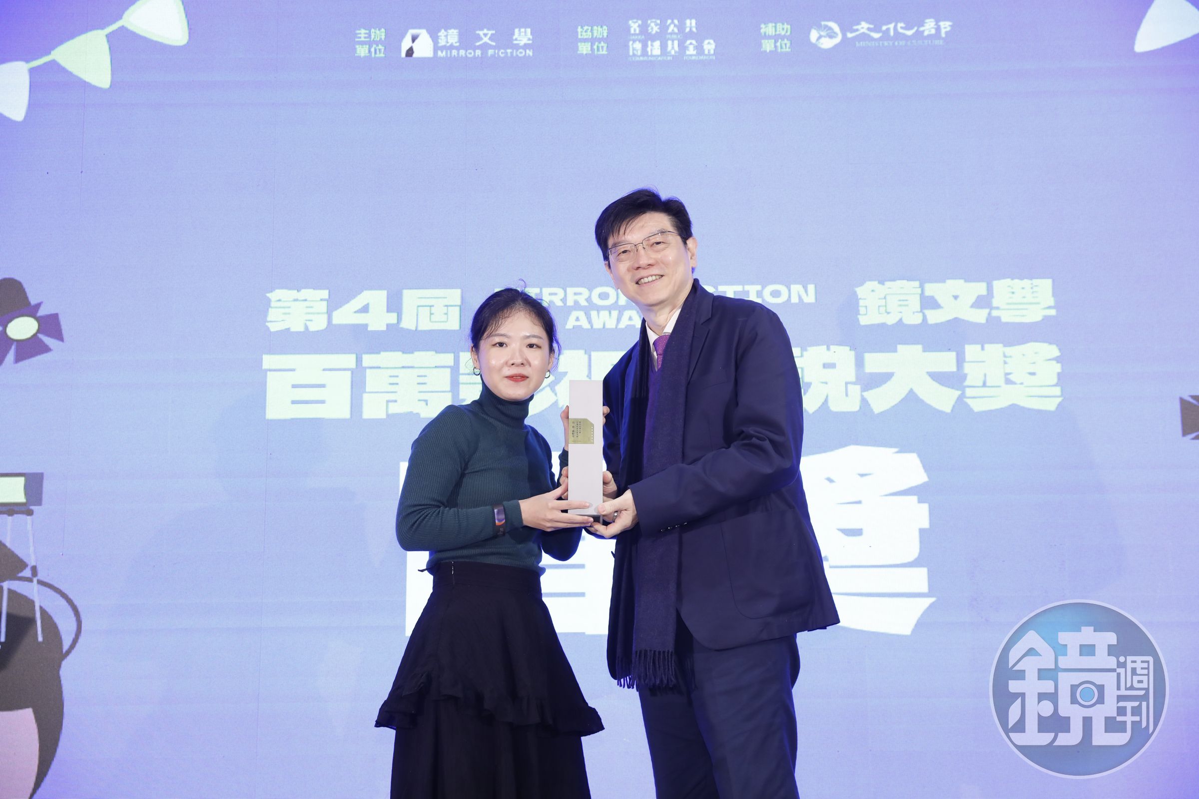 鏡文學社長裴偉（右）頒發第四屆鏡文學百萬影視小說大獎首獎給《海神》作者盧臆雯（左）（鏡文學提供）