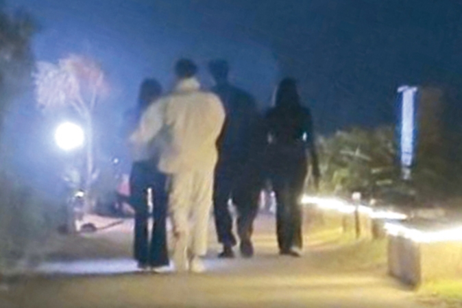 月光下，Andy老師（左二）伸手親密摟住李郁涵（左一）的腰。（讀者提供）