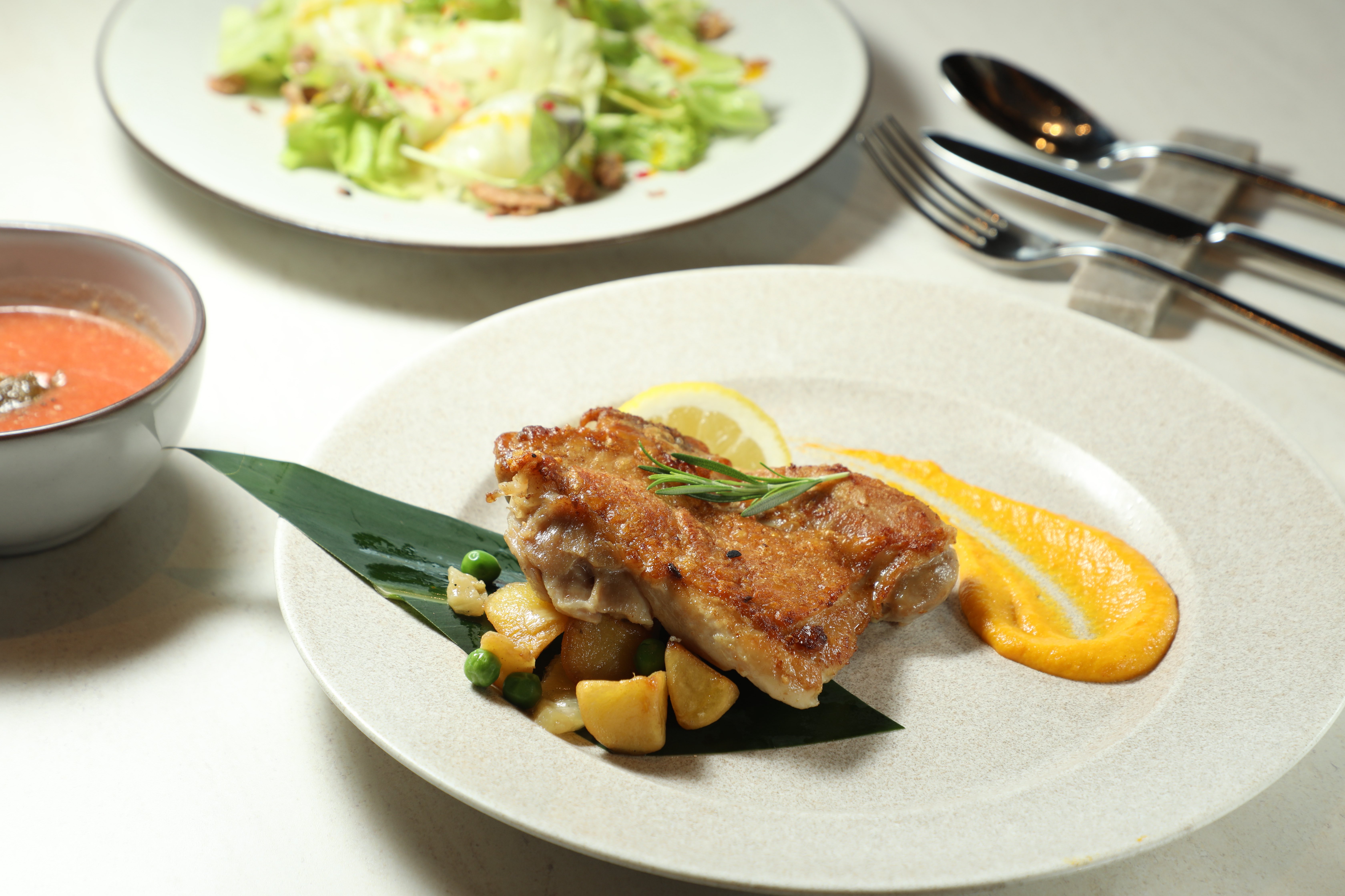 PANORAMA DINING的「炭烤香草山原雞」使用山原大自然孕育的香草雞，烤至外皮金黃酥脆。（3,000日圓／份，約NT$594）