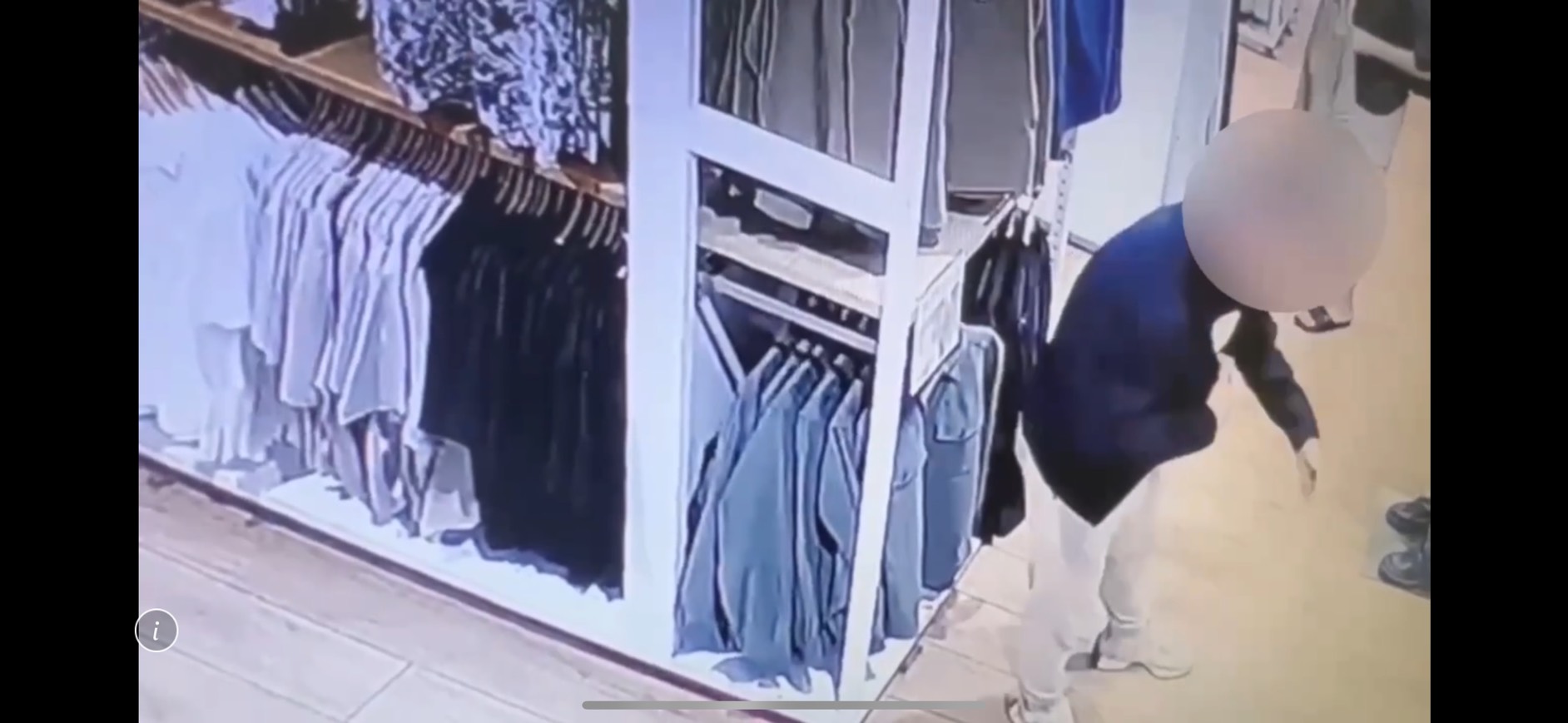 黃男在UNIQLO貨架前試穿外套。（翻攝畫面）