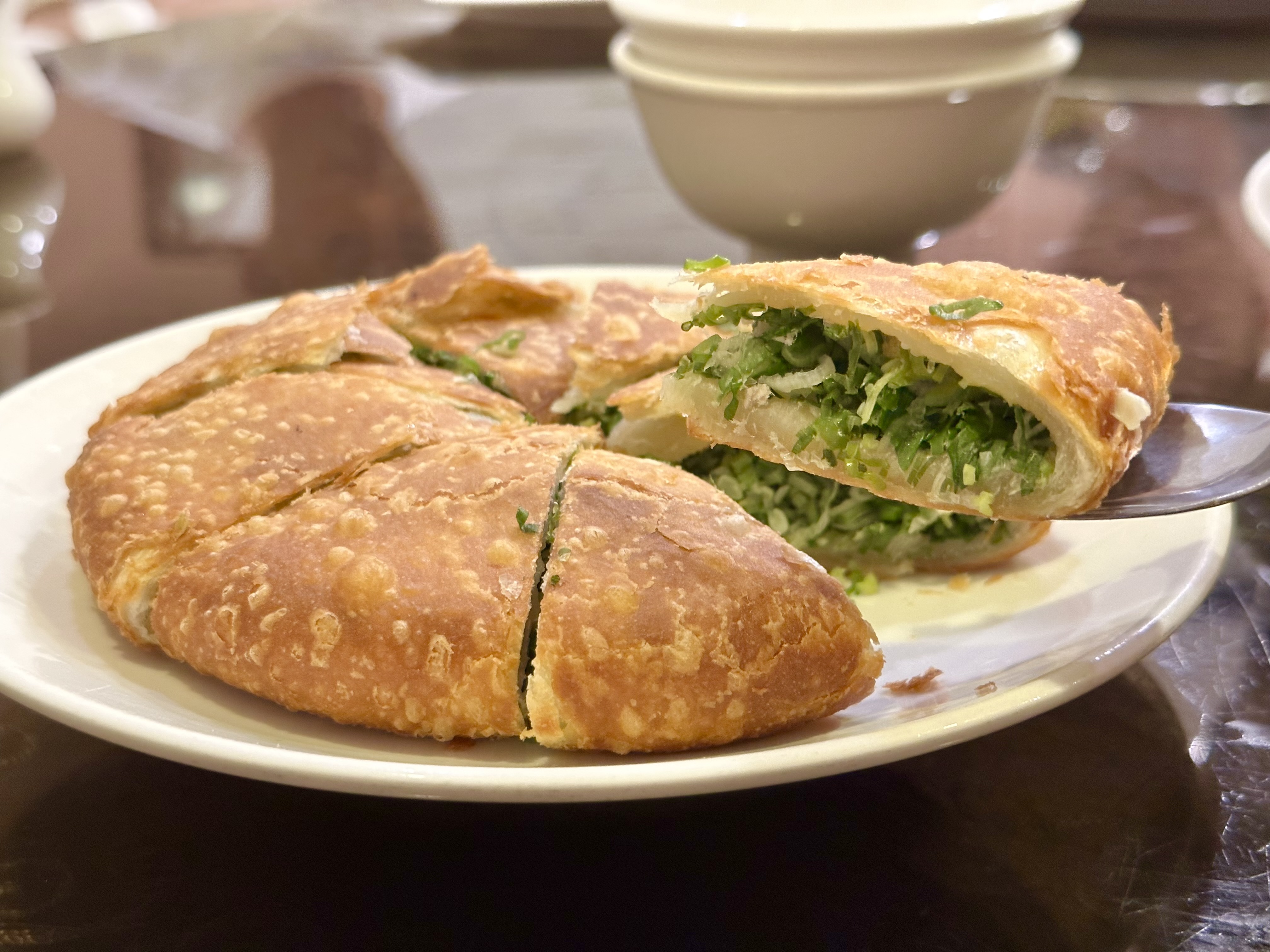 「厚餅」皮酥有嚼勁，每一口都能咬到滿滿蔥花。（200元／張）