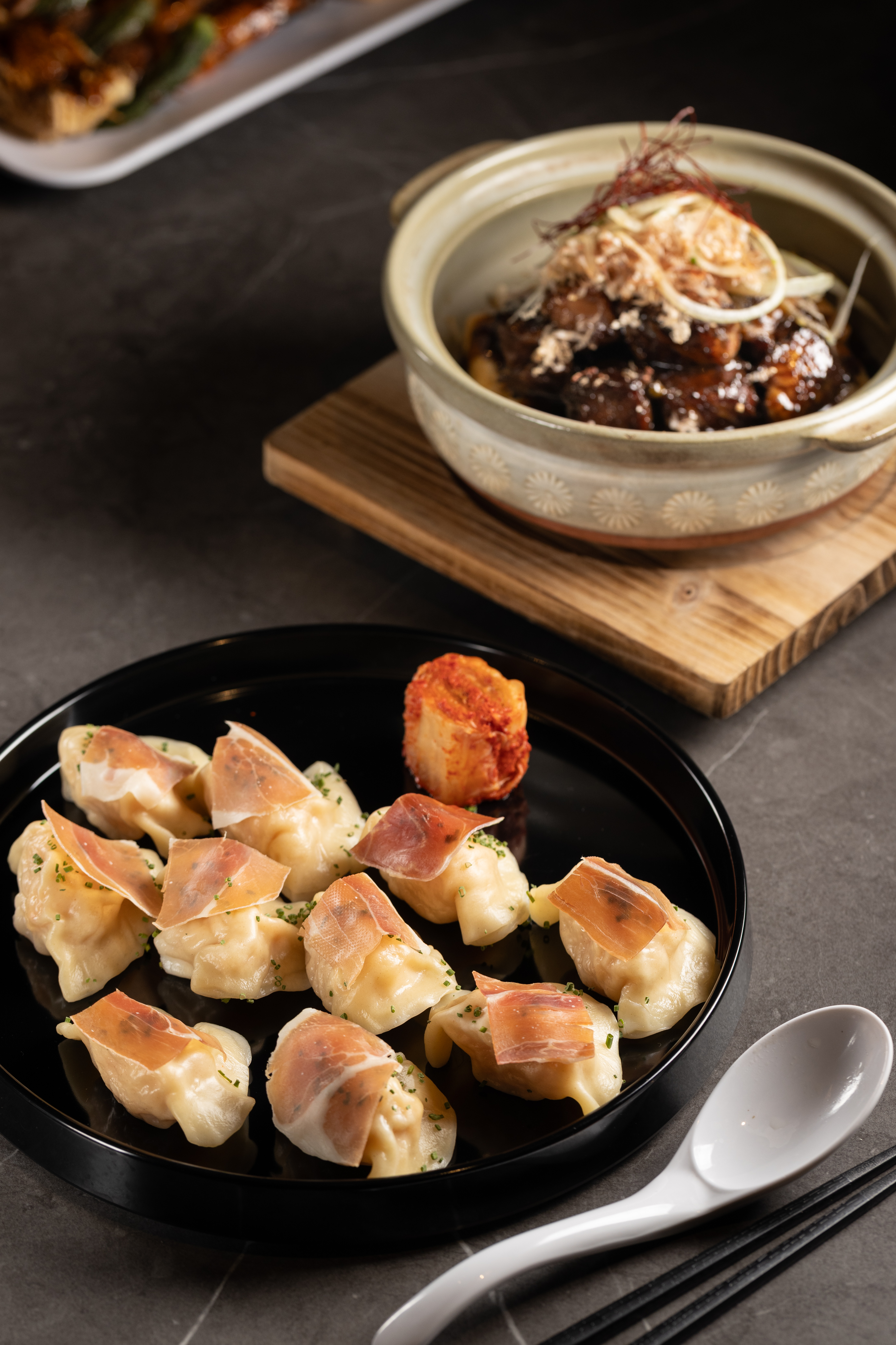 「媽媽的水餃」(前,330元/份)內裡為飽滿的鮮蝦與豬肉餡,搭配西班牙火腿;「壽喜黑椒骰子和牛」(後,1,280元/份)肉質軟嫩可口。