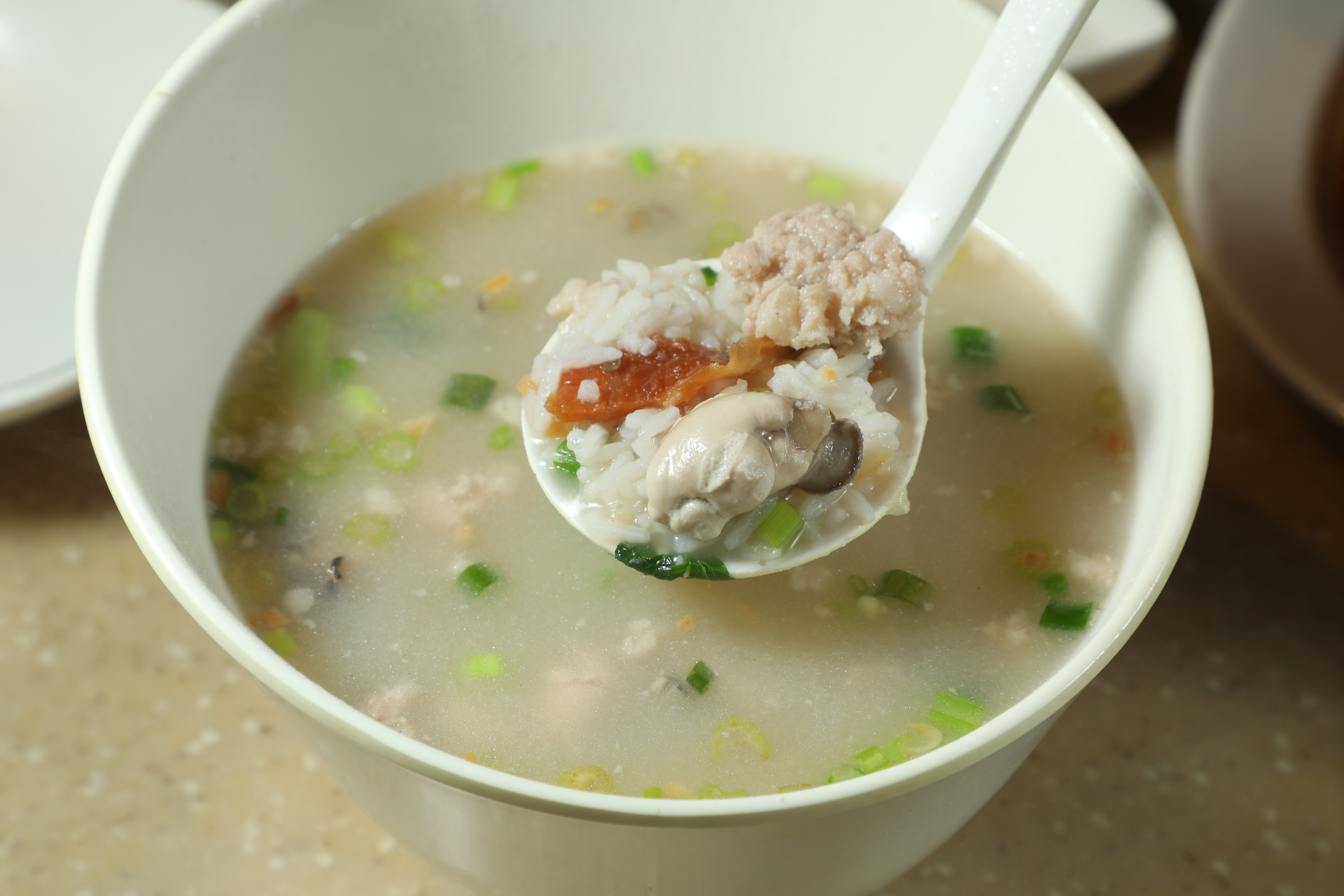 人氣招牌「蠔仔肉碎粥」以南薑、魷魚乾與大地魚乾熬粥底，粒粒牡蠣飽滿鮮香，整碗全是大海精華。（港幣75元／小份）
