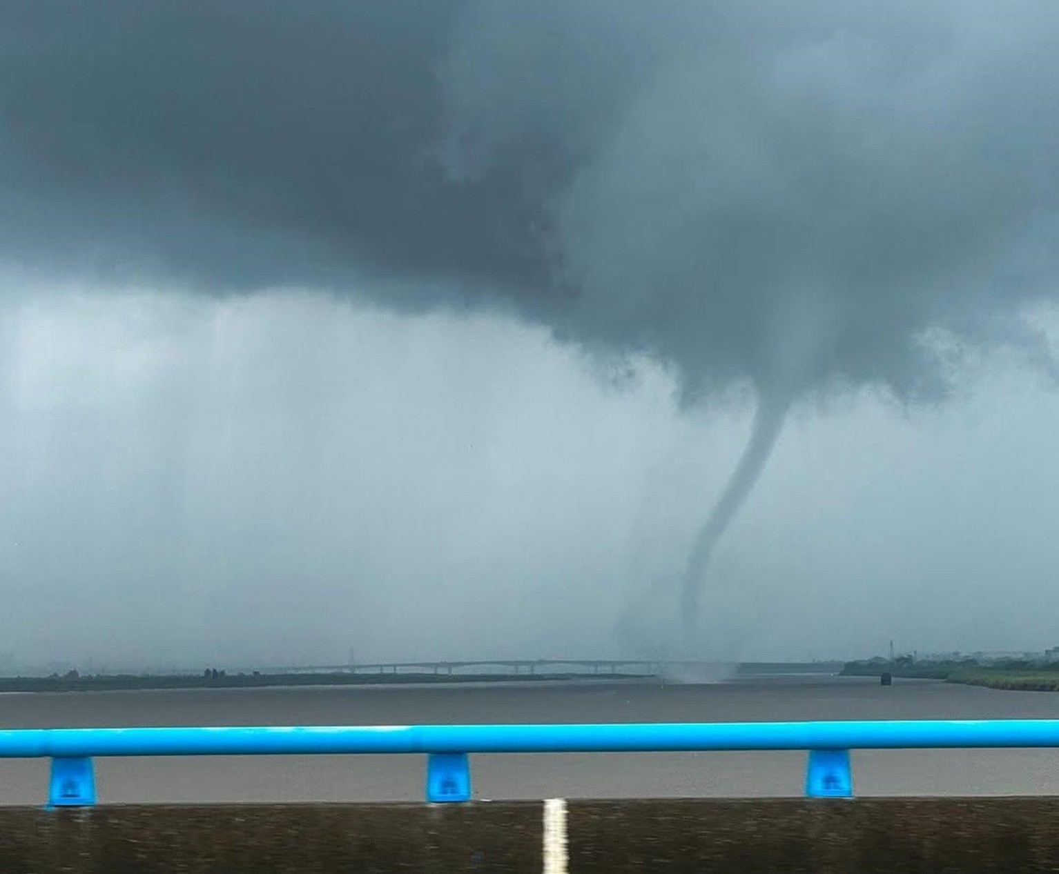 有網友於昨日11時50分於屏東往高雄的萬大橋上目擊到龍捲風，而其位於屏東萬丹，並可見其有觸地、揚起地表沙塵的現象。（翻攝自臉書@報天氣 - 中央氣象署）