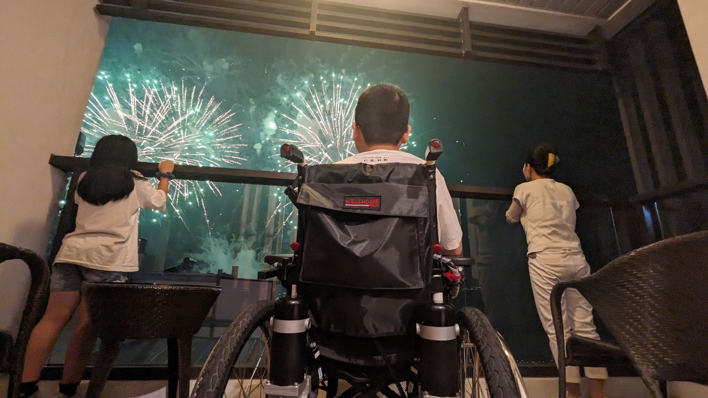 一名尚須依賴輪椅的重傷馨生人看到震天動地的煙火釋放，忍不住巍巍顫顫站起來倚著欄杆，希望更靠近耀眼的煙火。（犯保提供）