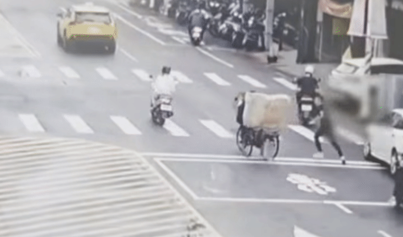 桃園八德「擋車哥」和轎車駕駛發生衝突，兩人當街互毆扭打。（翻攝畫面）