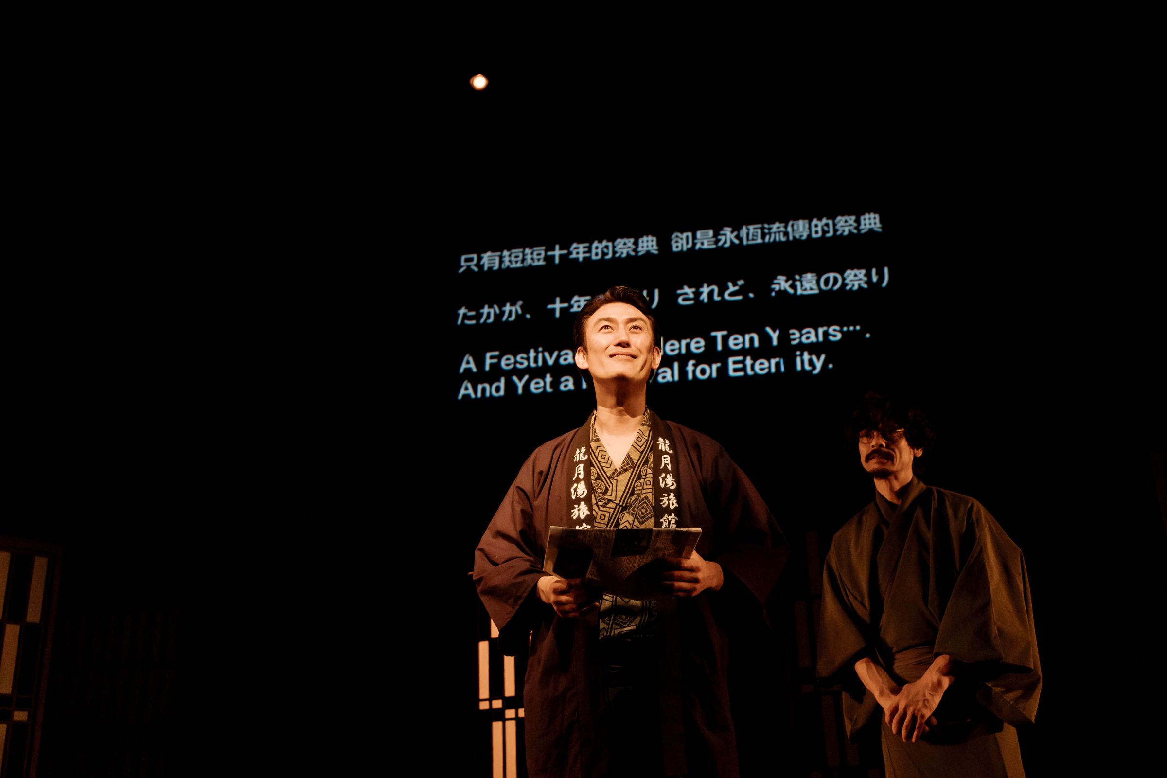 塚原大助(左)《這十年,我們的祭典》去年在台演出,以3種語言字幕來呈現。(山峸製作設計提供)