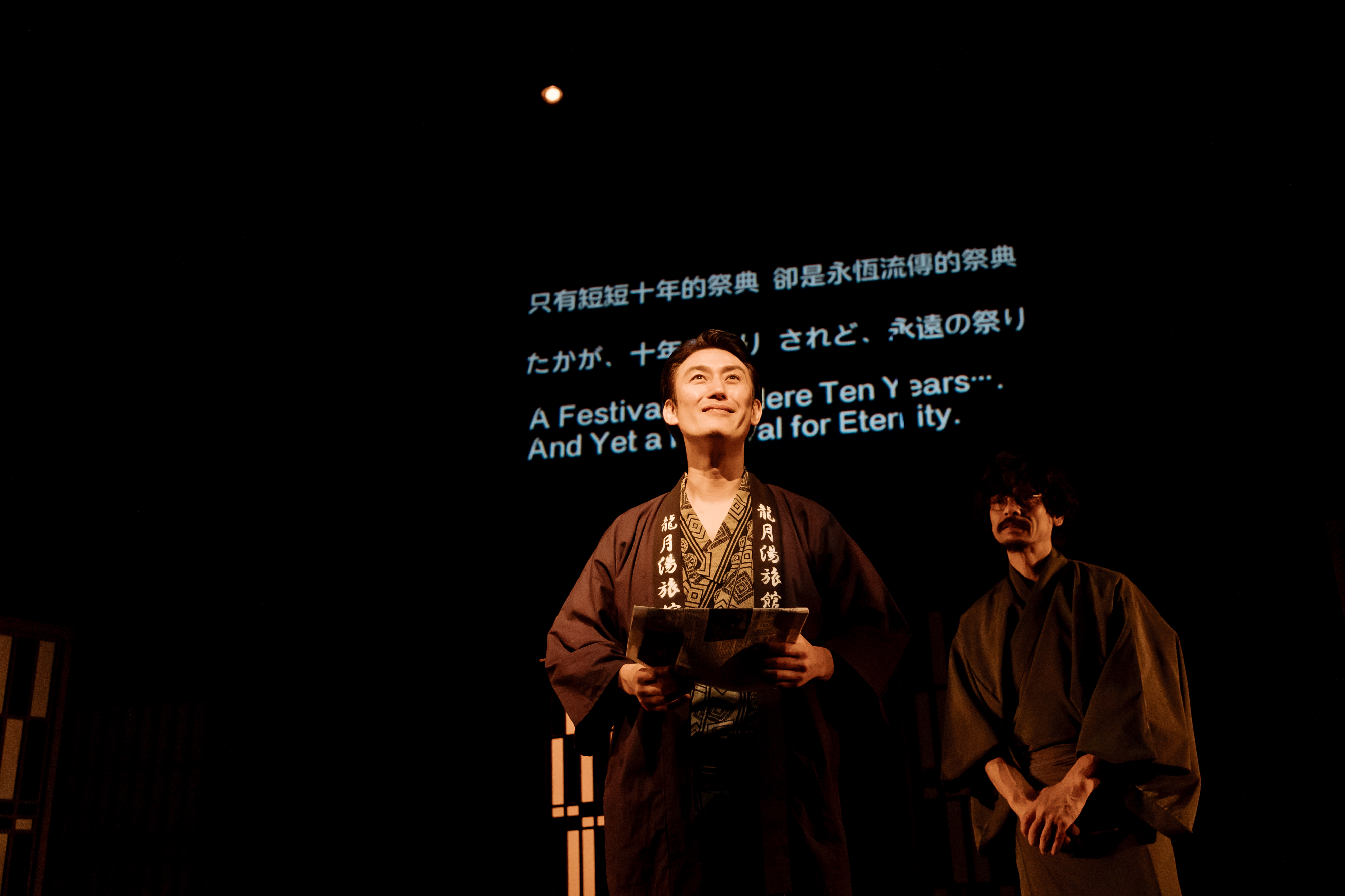 塚原大助（左）《這十年，我們的祭典》去年在台演出，以3種語言字幕來呈現。（山峸製作設計提供）