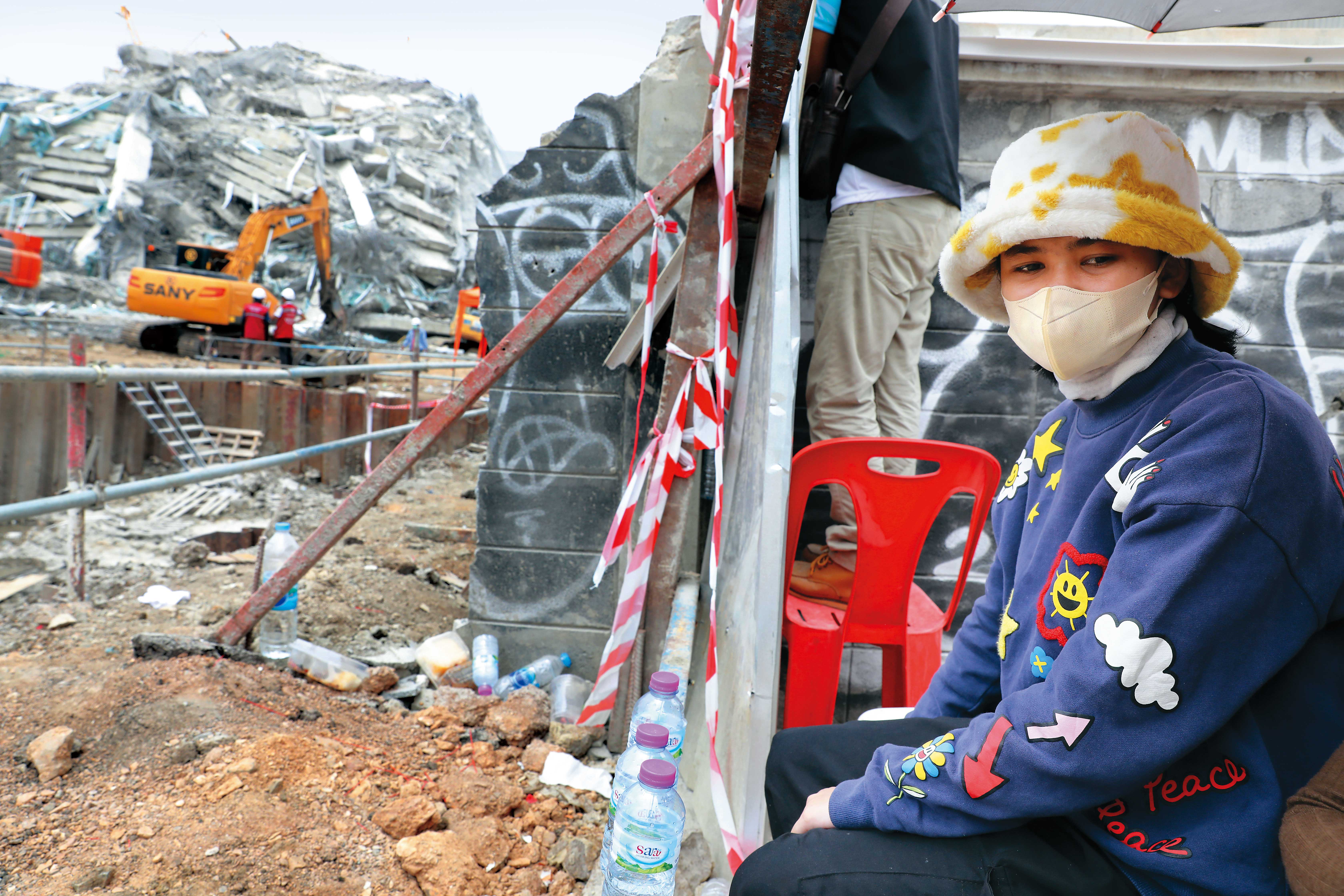 一名泰國女子在曼谷塌樓現場焦急等待，期盼親人能平安獲救。