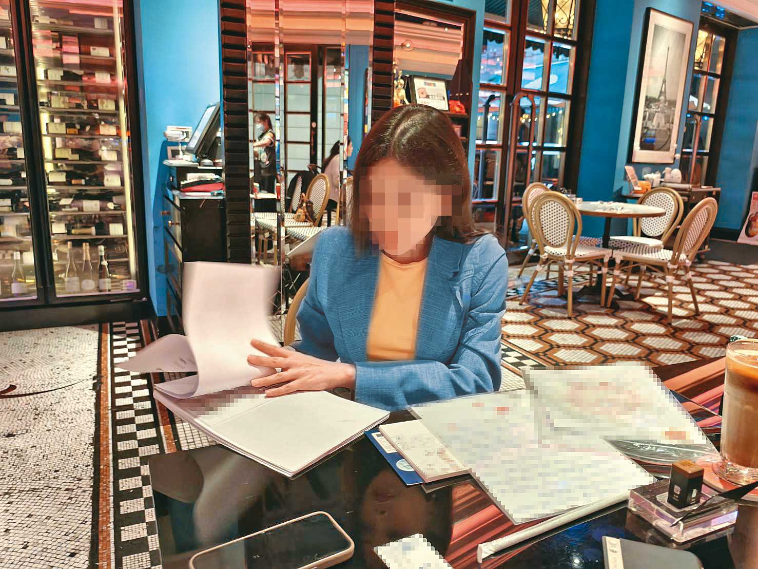 S小姐攤開厚厚一疊資料，其中包含對方親筆寫下的自白悔過書。保護當事人，圖片經變裝處理。（吳苡辰攝）