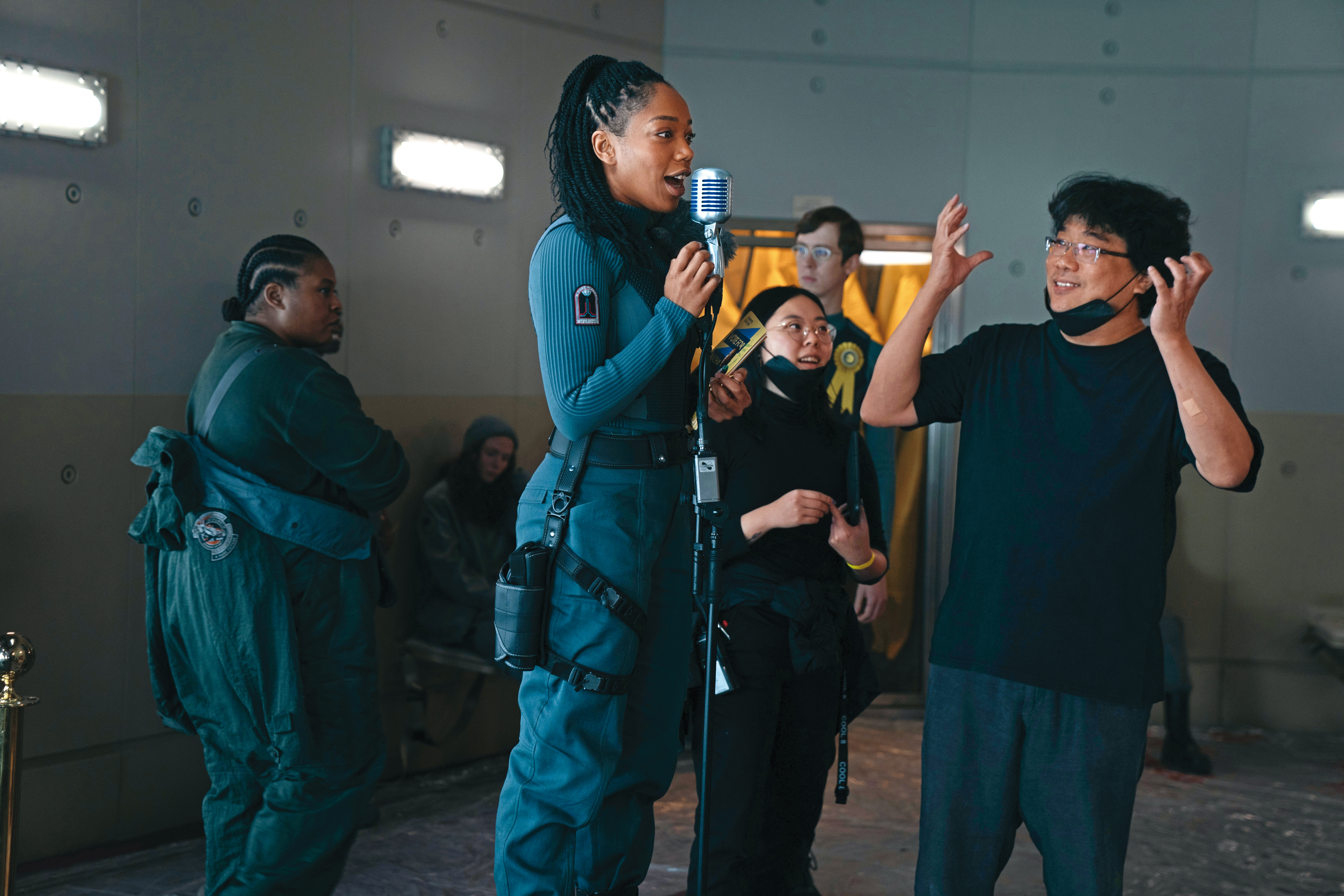 《米奇17號》是奉俊昊（右一）第三部英語電影，在片場他透過口譯Sharon Choi（右二）與演員溝通。（華納兄弟電影提供）