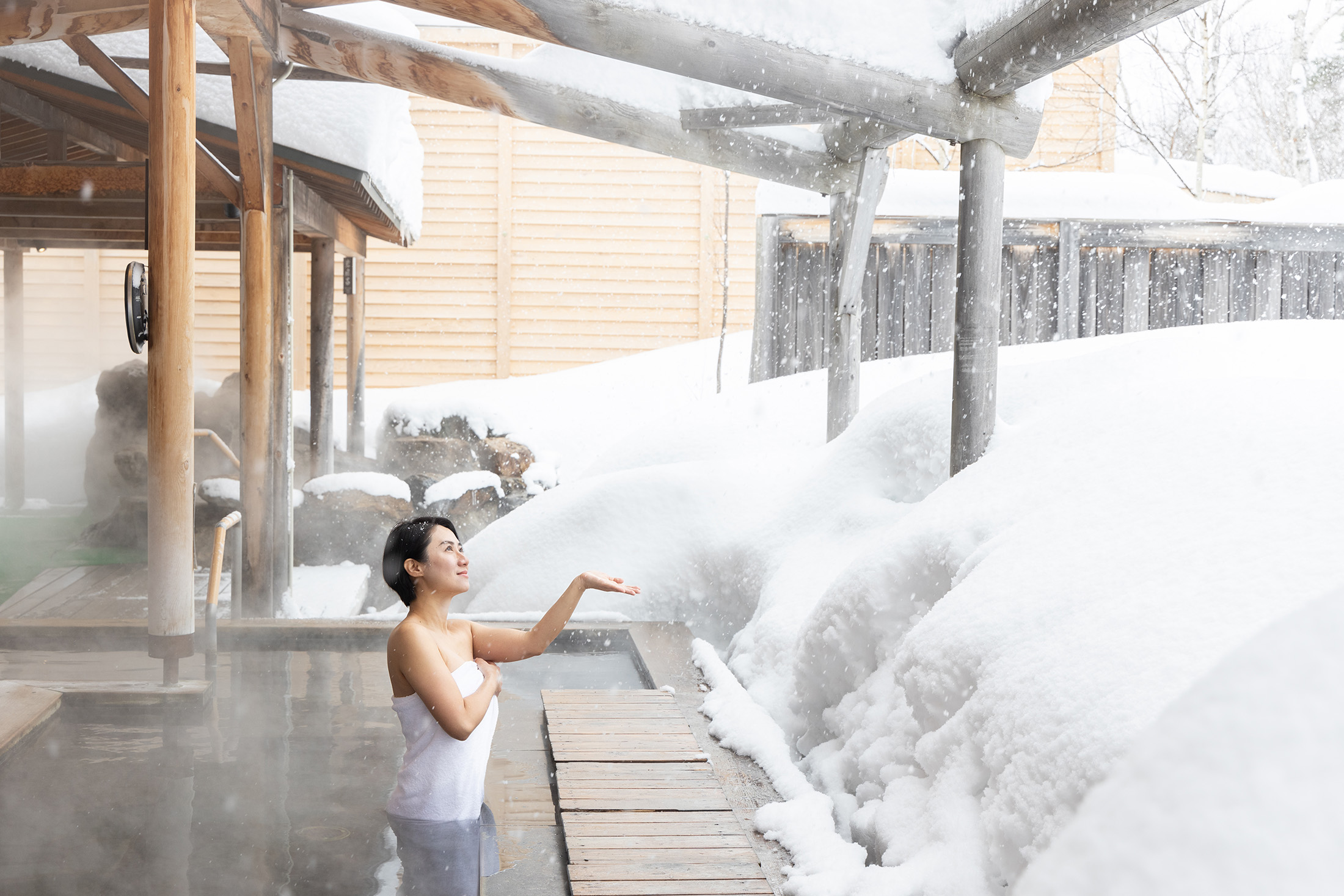 在「白樺之湯」享受露天溫泉的療癒感,看著眼前木造建築與白雪皚皚交織的夢幻景色,身心都得到滿足與放鬆。