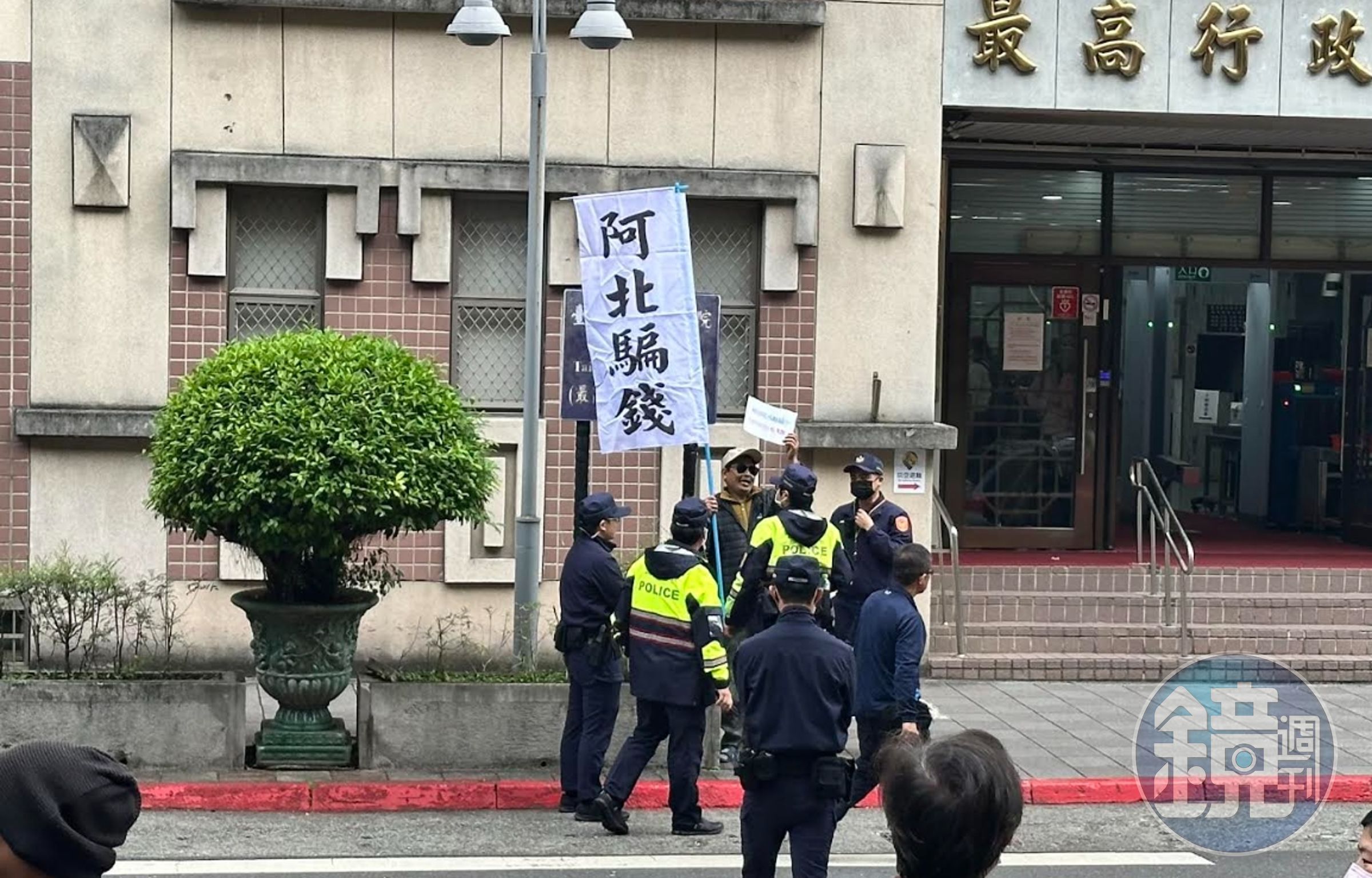 台北地院前有民眾持「阿北騙錢」標語與柯文哲的支持者對峙。