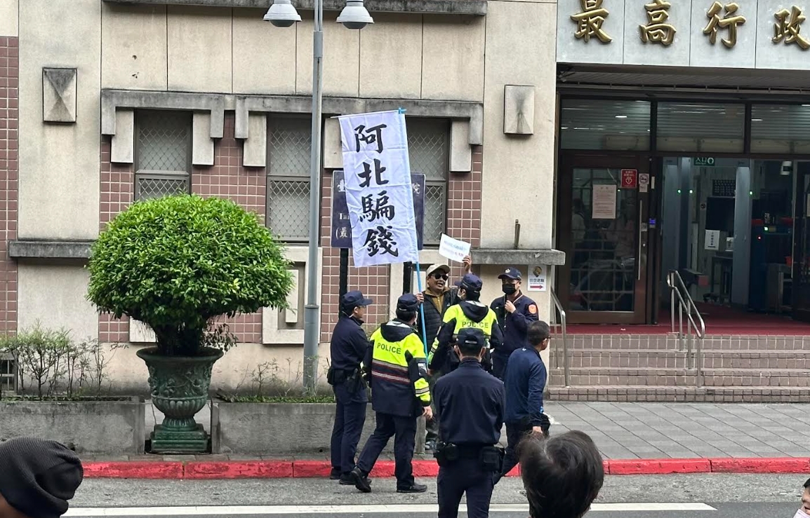 台北地院前有民眾持「阿北騙錢」標語與柯文哲的支持者對峙。