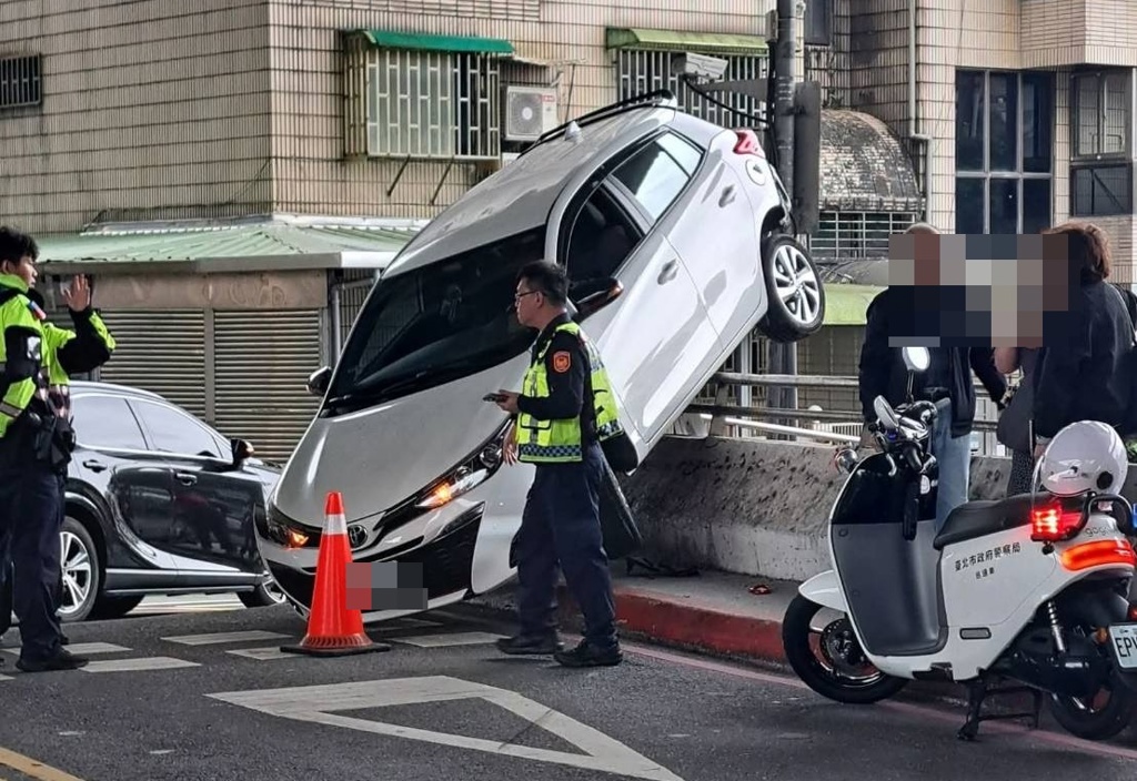 一名婦人今日前往汐止林森市場買菜，開車離去時疑打錯檔，導致車子往後暴衝，撞上橋邊半個車身懸空，十分駭人。（翻攝自記者爆料網）