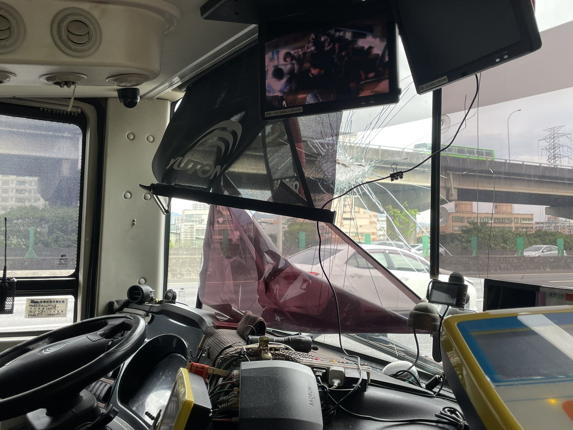 一輛遊覽車行經國道1號三重五股路段，遭飛來鐵片擊穿擋風玻璃。（翻攝畫面）