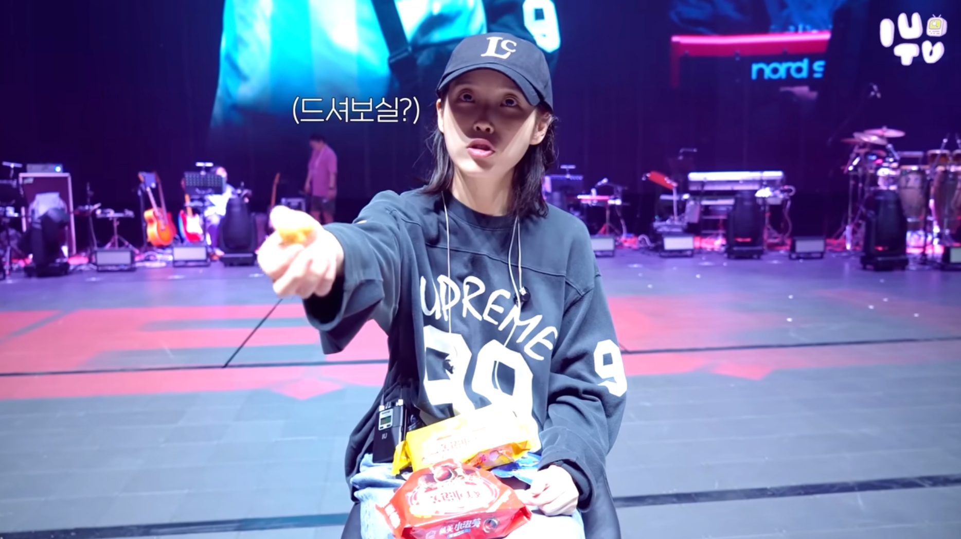 IU在台北小巨蛋彩排時開心吃義美小泡芙，還分給工作人員一起。（截圖自IU Official YT）