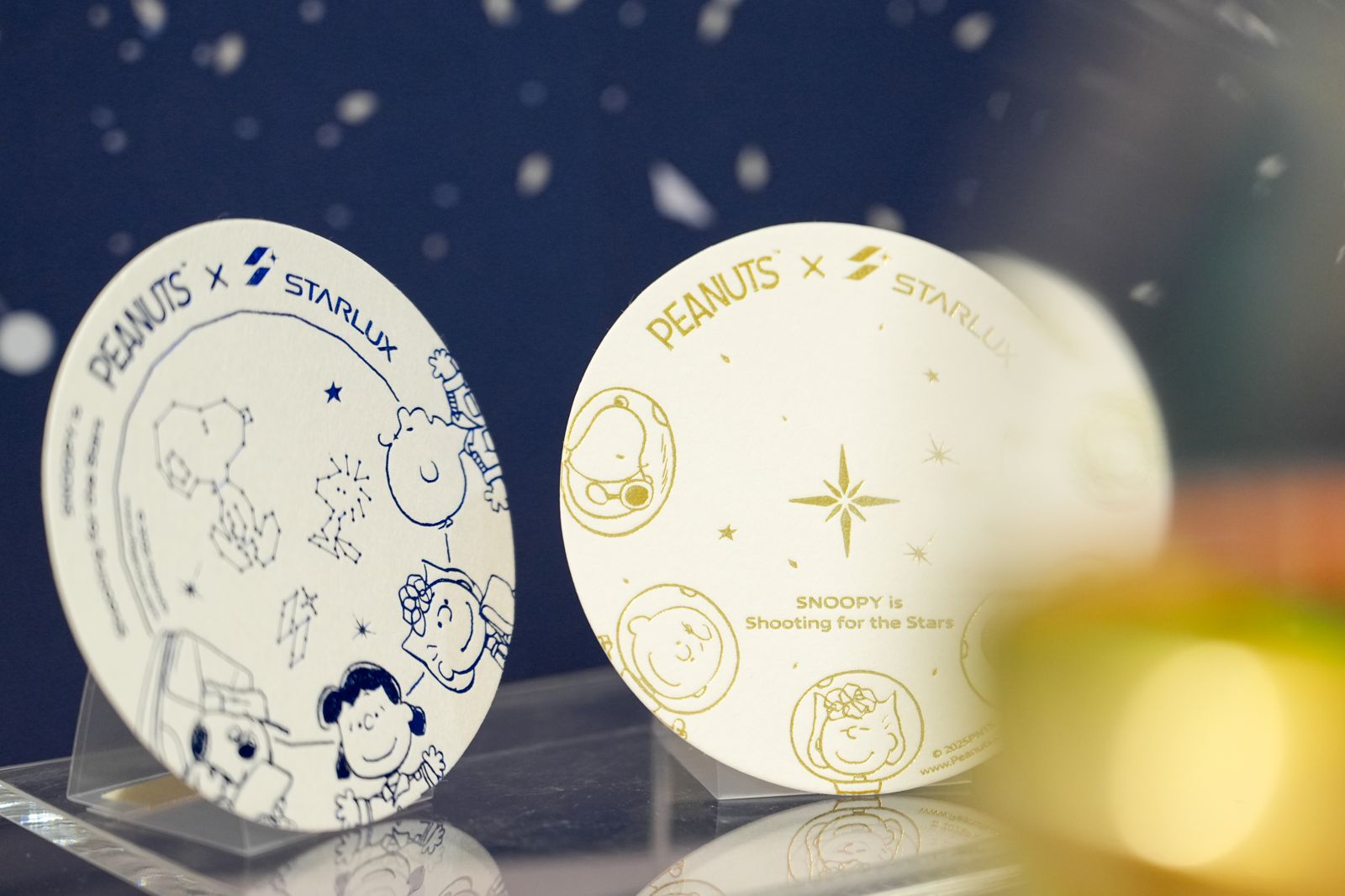有別於去年的航空繽紛元素,此次以宇宙藍及星光金為主要色調,圖為頭等艙以及商務艙杯墊。