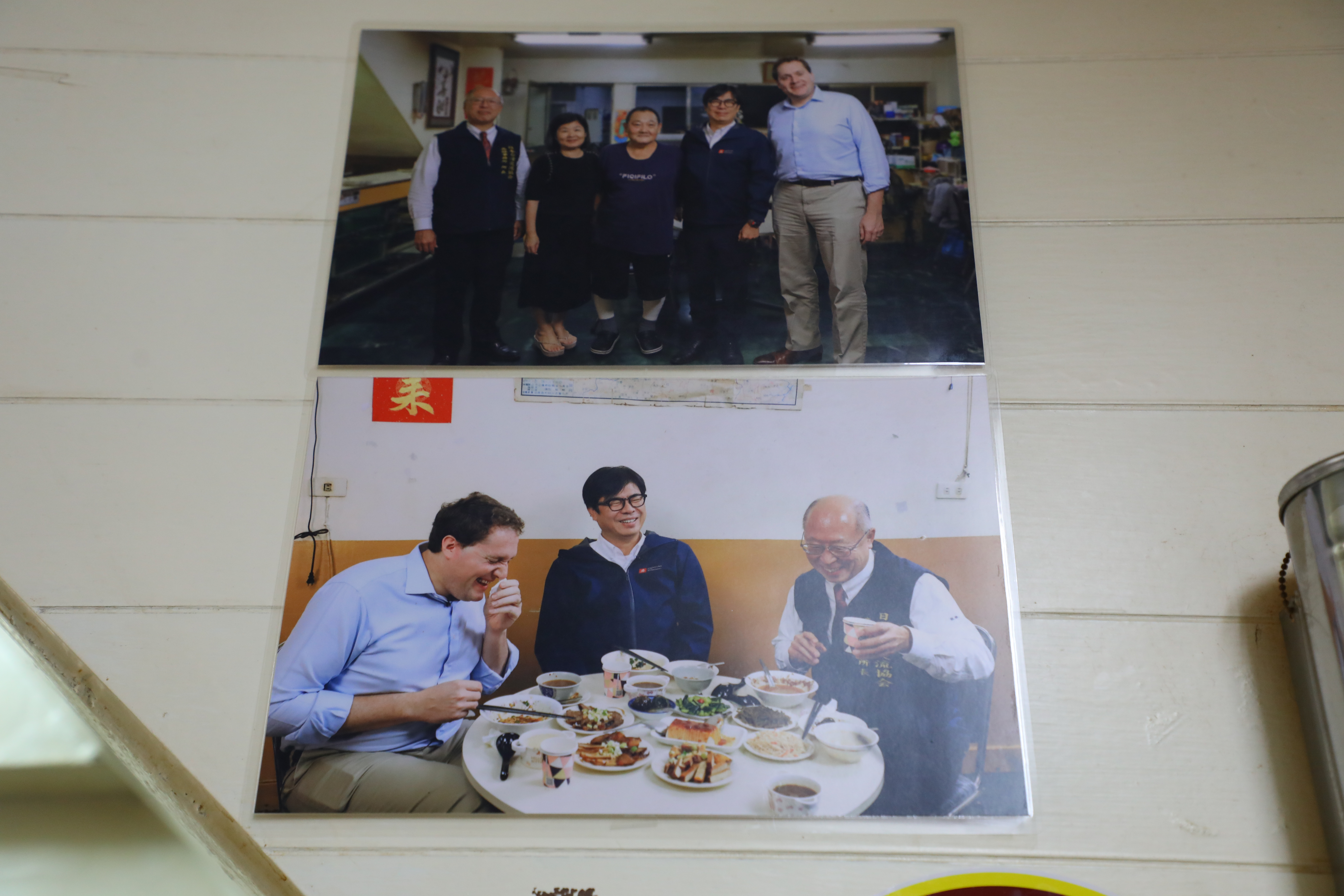 牆上貼著高雄市長陳其邁招待國際友人來吃牛肉麵的照片。