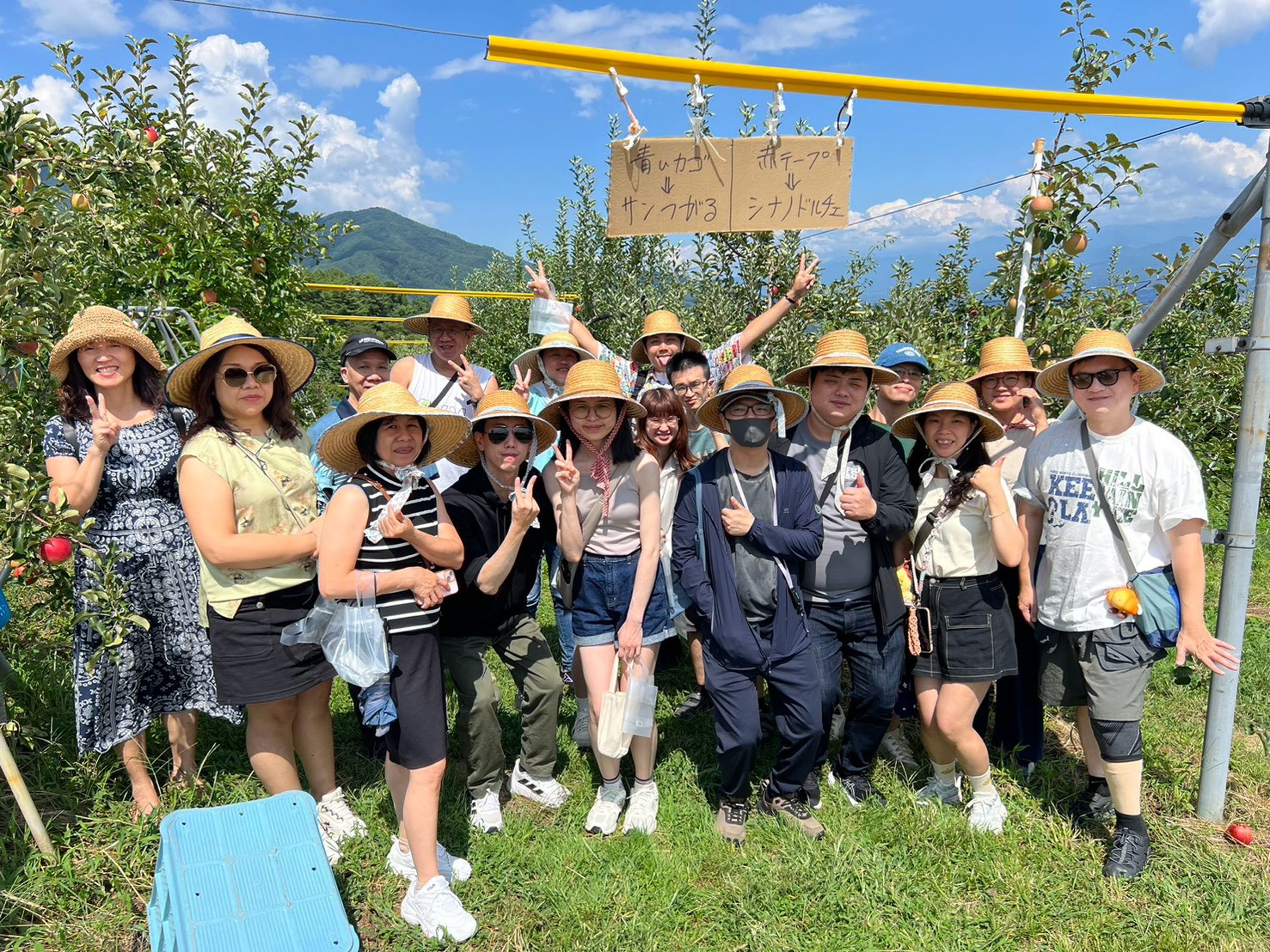 饗賓集團有不少同事到日本立山黑部周邊的長野縣,在當地觀光果園採蘋果,最後一起開心大合照。(饗賓集團提供)
