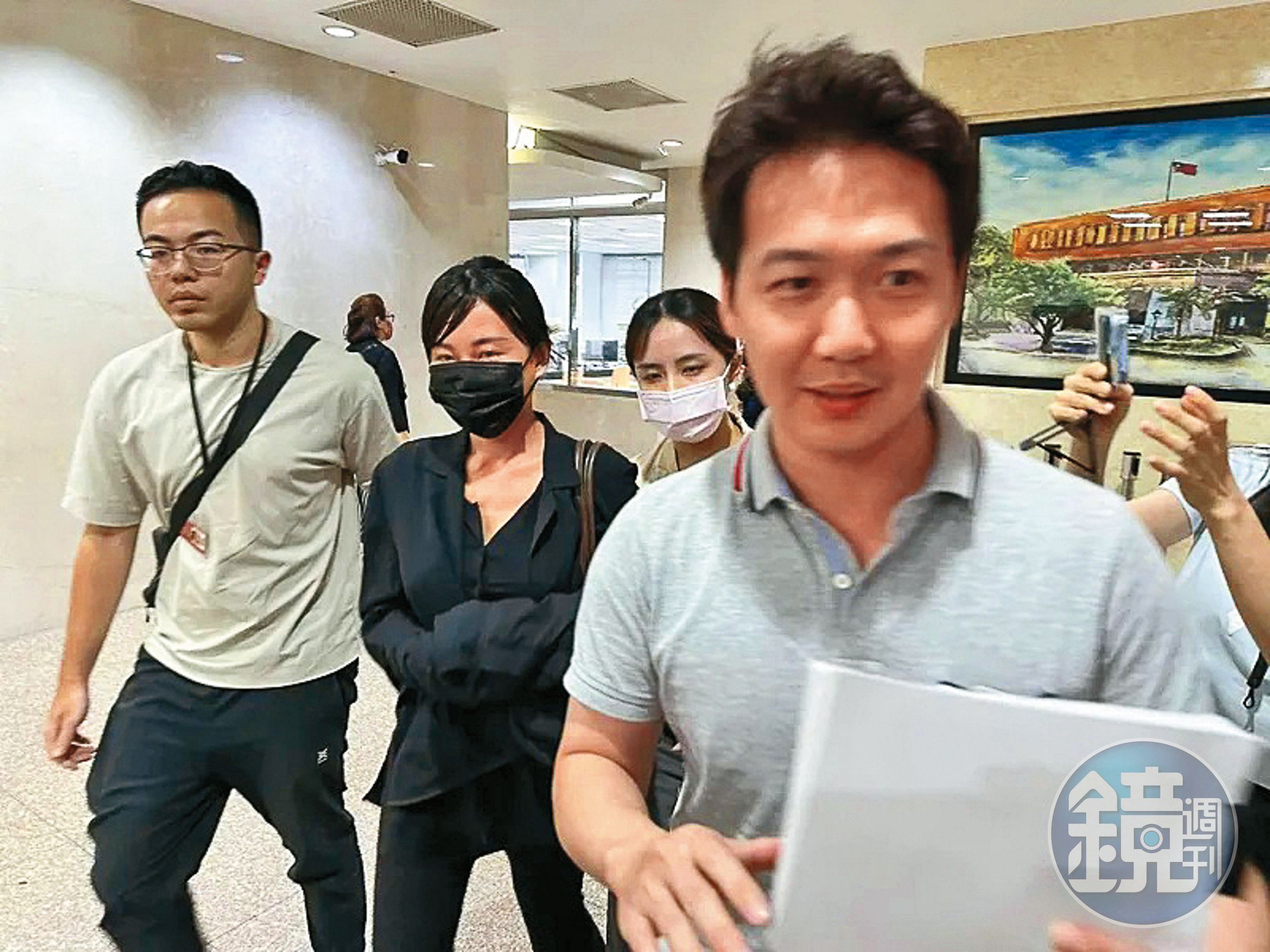 仙塔律師（左二）遭檢警偵訊時面無表情，但因被上銬，被法界認定涉案嚴重。