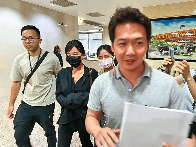 仙塔律師（左二）遭檢警偵訊時面無表情，但因被上銬，被法界認定涉案嚴重。