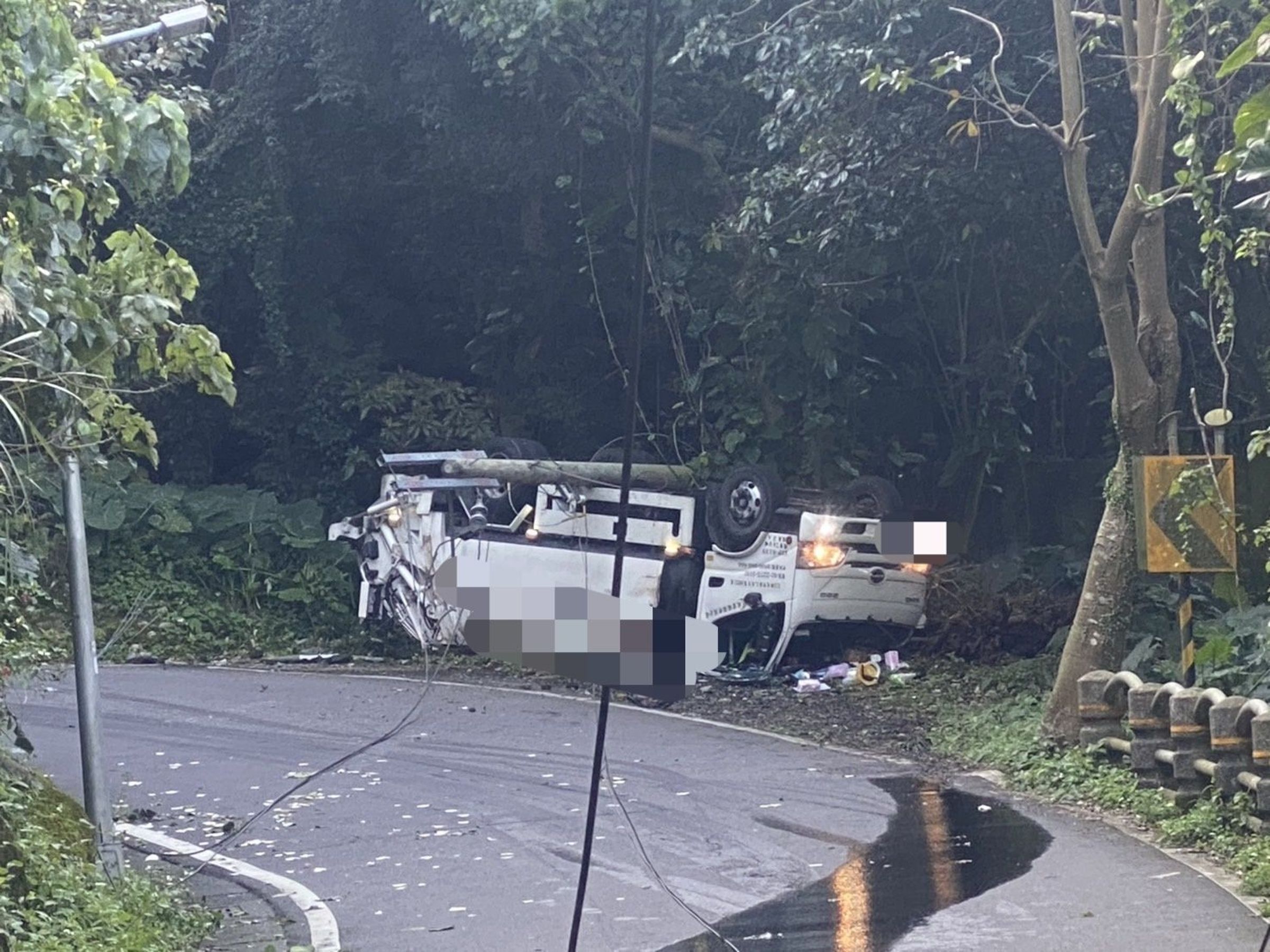 一輛民間垃圾車行經文化大學後山時擦撞電線桿翻覆，駕駛僅輕傷。（翻攝畫面）