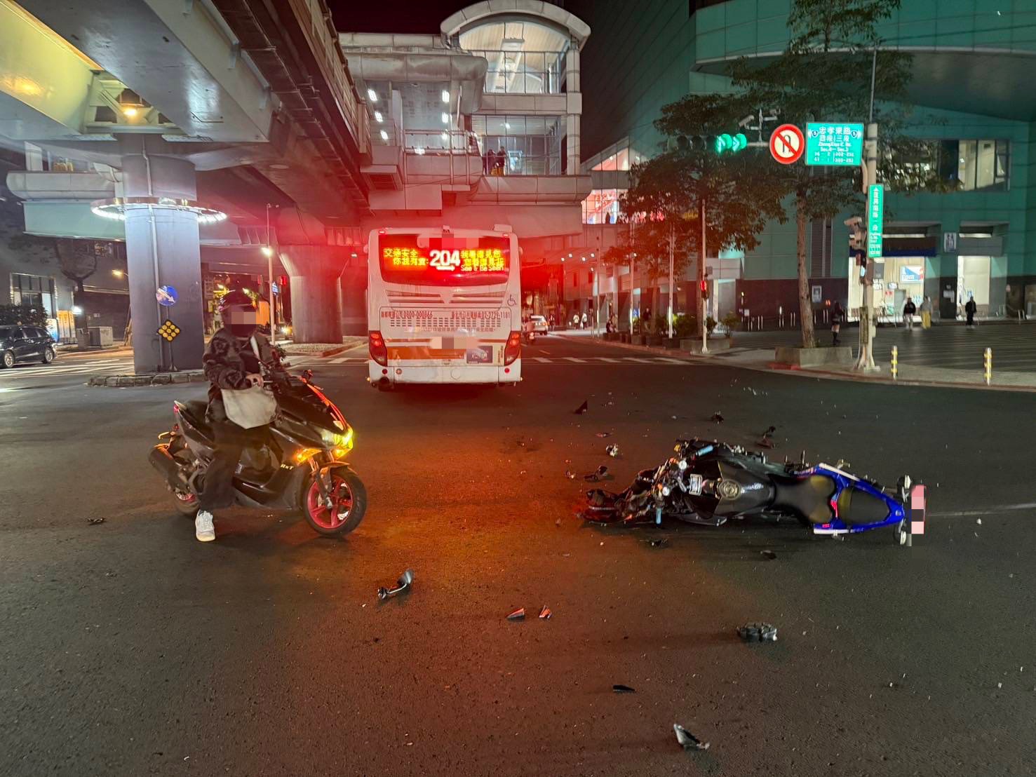 一輛204公車昨深夜行經忠孝東路四段，欲左轉復興南路一段，疑似未禮讓，造成急駛直行的大型重機失控直接滑行撞上，重機車頭全毀。（翻攝畫面）