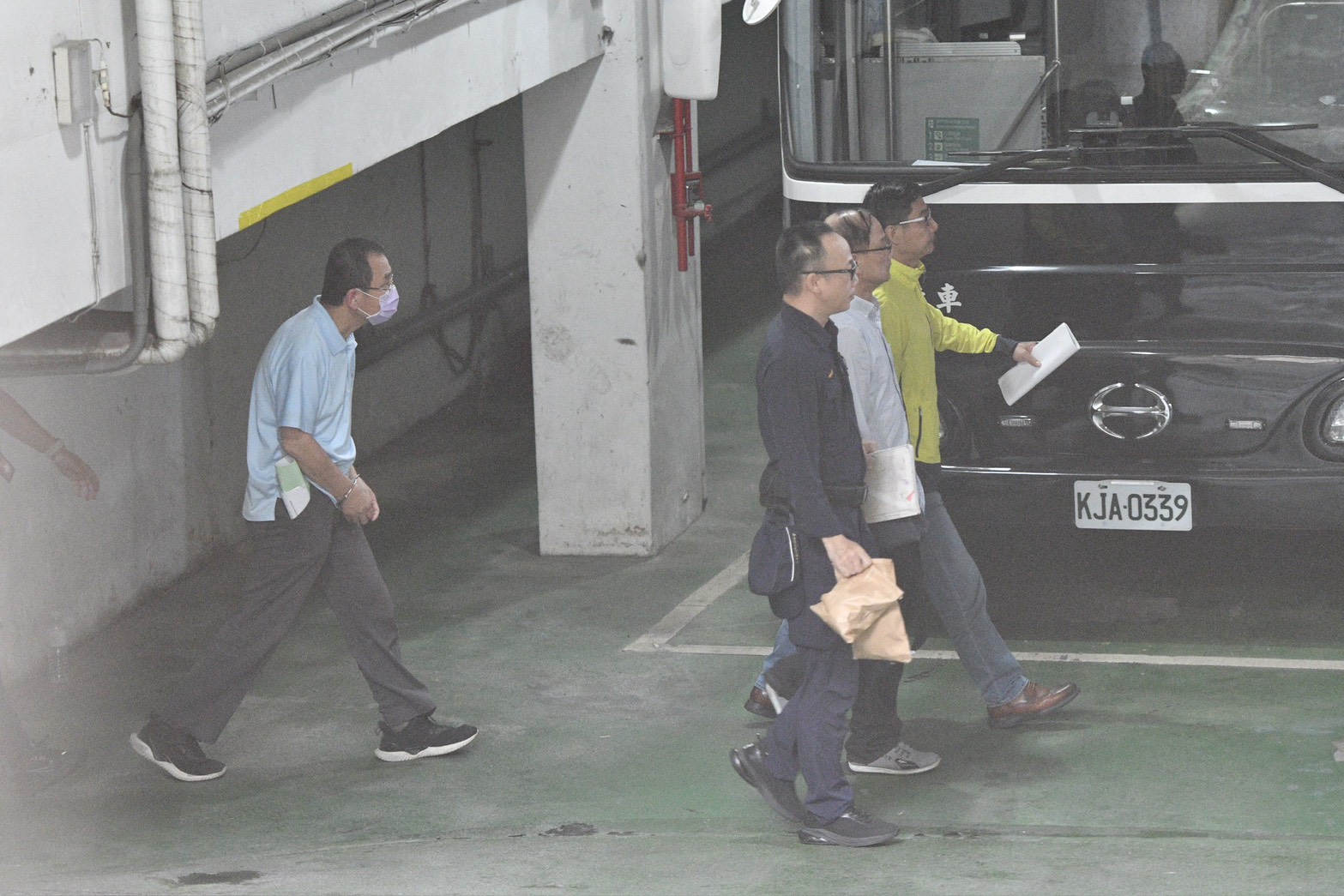 初文卿(後方藍衣)、姚富文(綠色外套)2人大量非法使用他人個資,且有LINE對話紀錄情形,有滅證之虞,今清晨5時許裁定2人均羈押禁見。