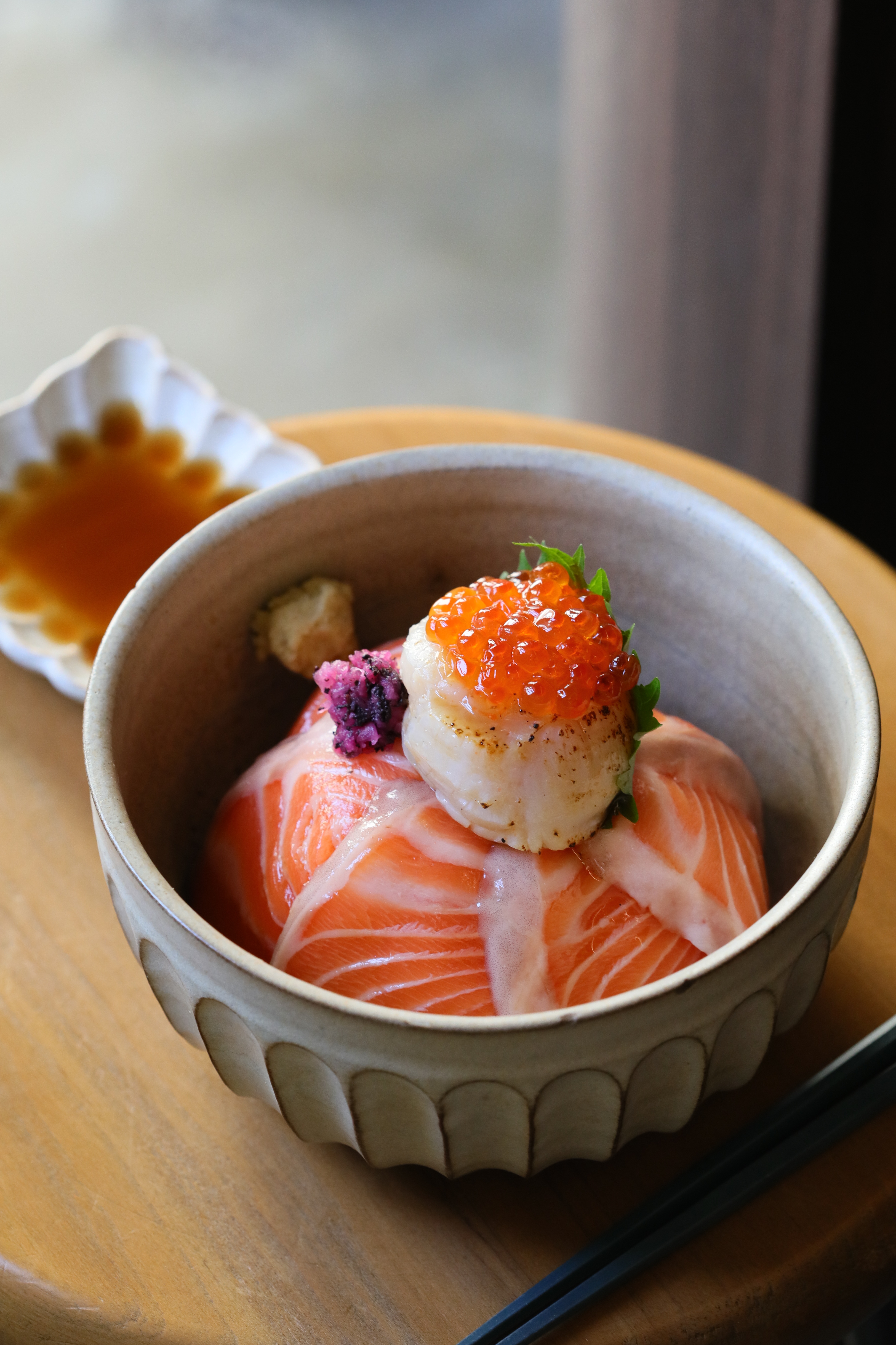 人氣招牌「鮭魚親子干貝丼」鮭魚厚切搭配炙燒過的日本進口干貝。（680元／份）