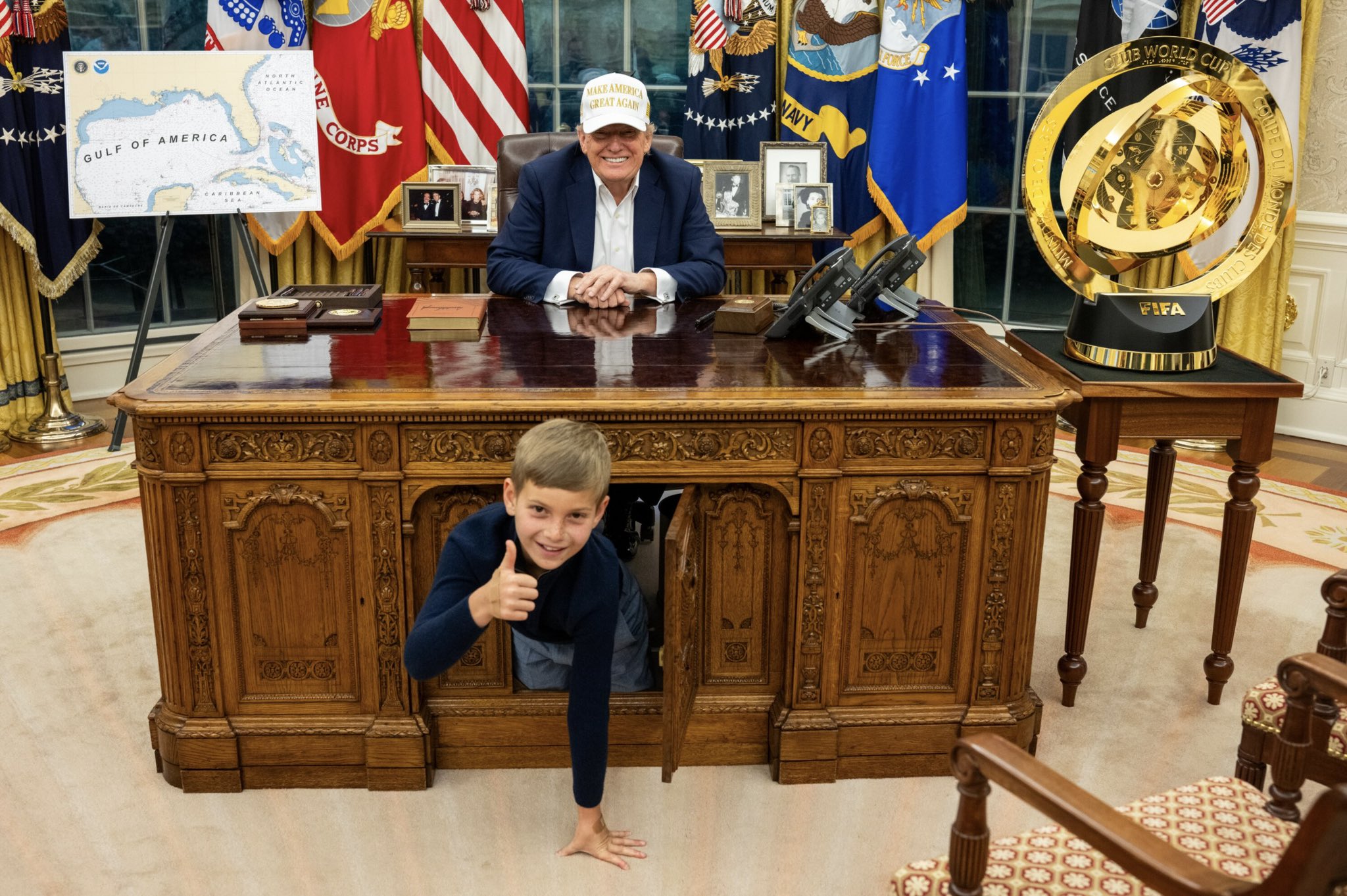 西奧多鑽到「堅毅著」底下，阿公川普樂呵呵。（翻攝X@IvankaTrump）