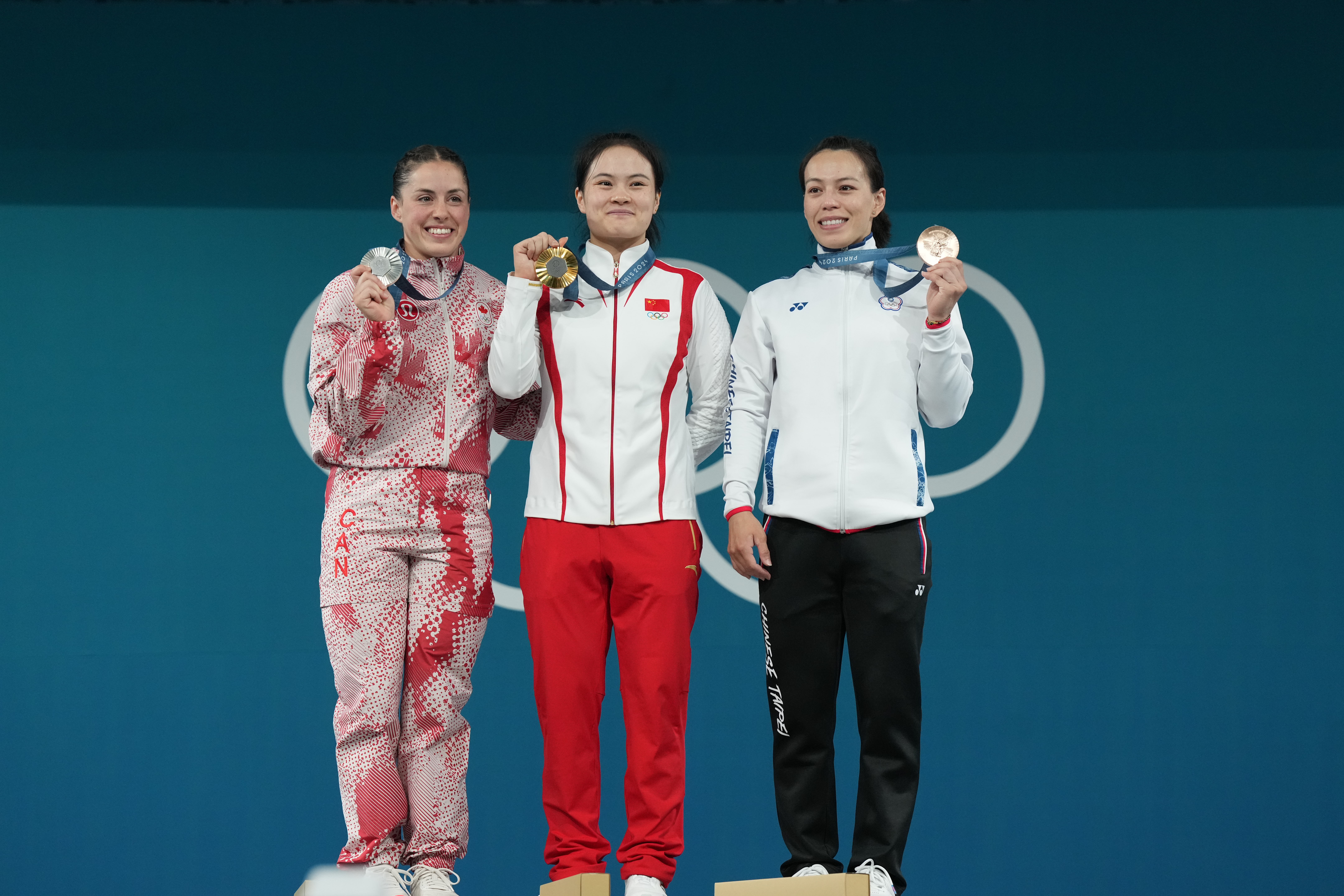 中國選手羅詩芳（中）以抓107公斤、挺舉134公斤，加總241公斤奪下金牌，「舉重女神」郭婞淳（右）帶傷奮力奪下銅牌。（中華奧會提供）